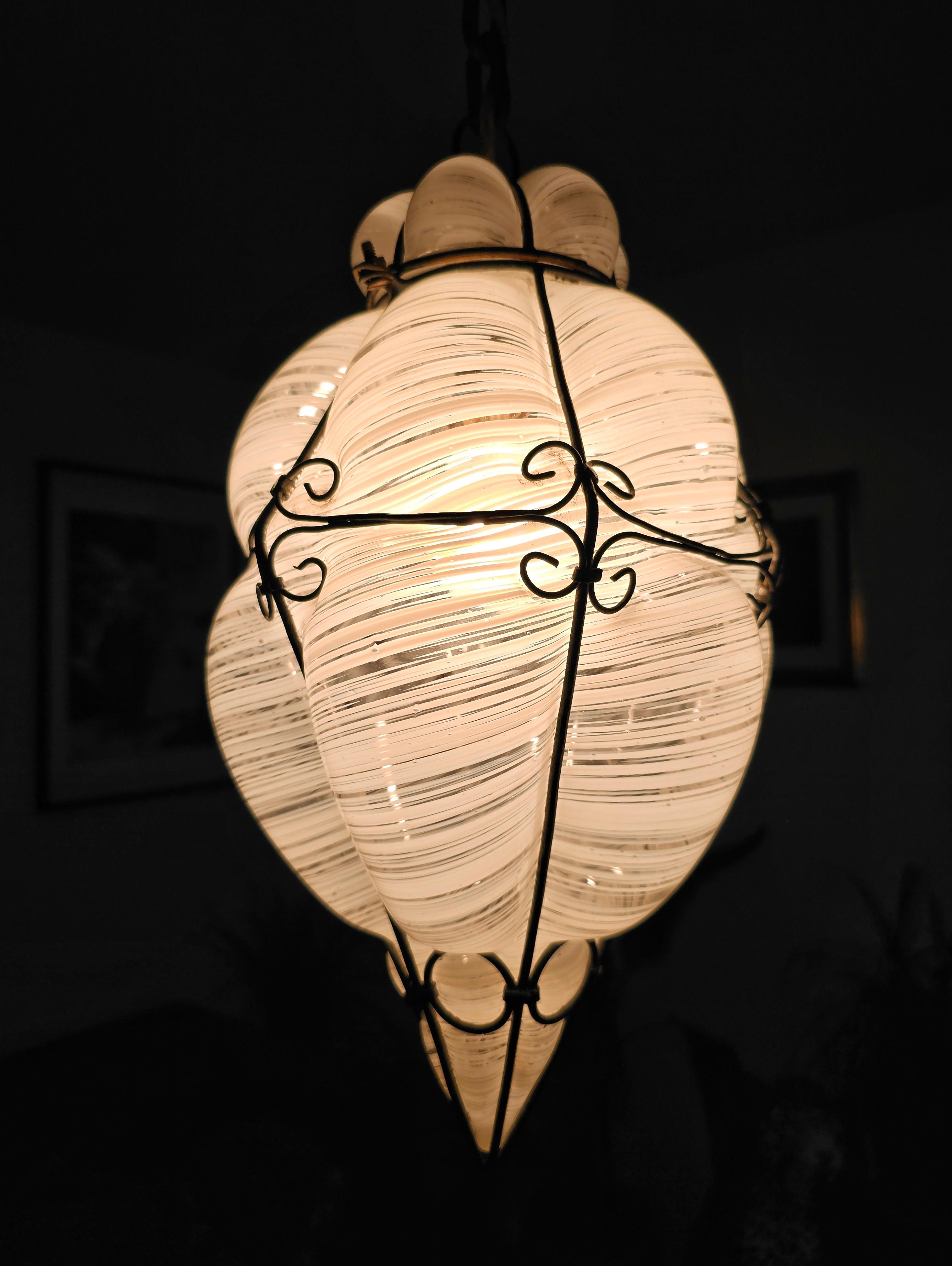 In this listing you will find a striking mouthblown Murano caged glass lantern designed by Archimede Seguso in Italy in late 1940s. It features gorgeous white and clear swirl glass, done in a traditional Venetian style of blowing the glass into an