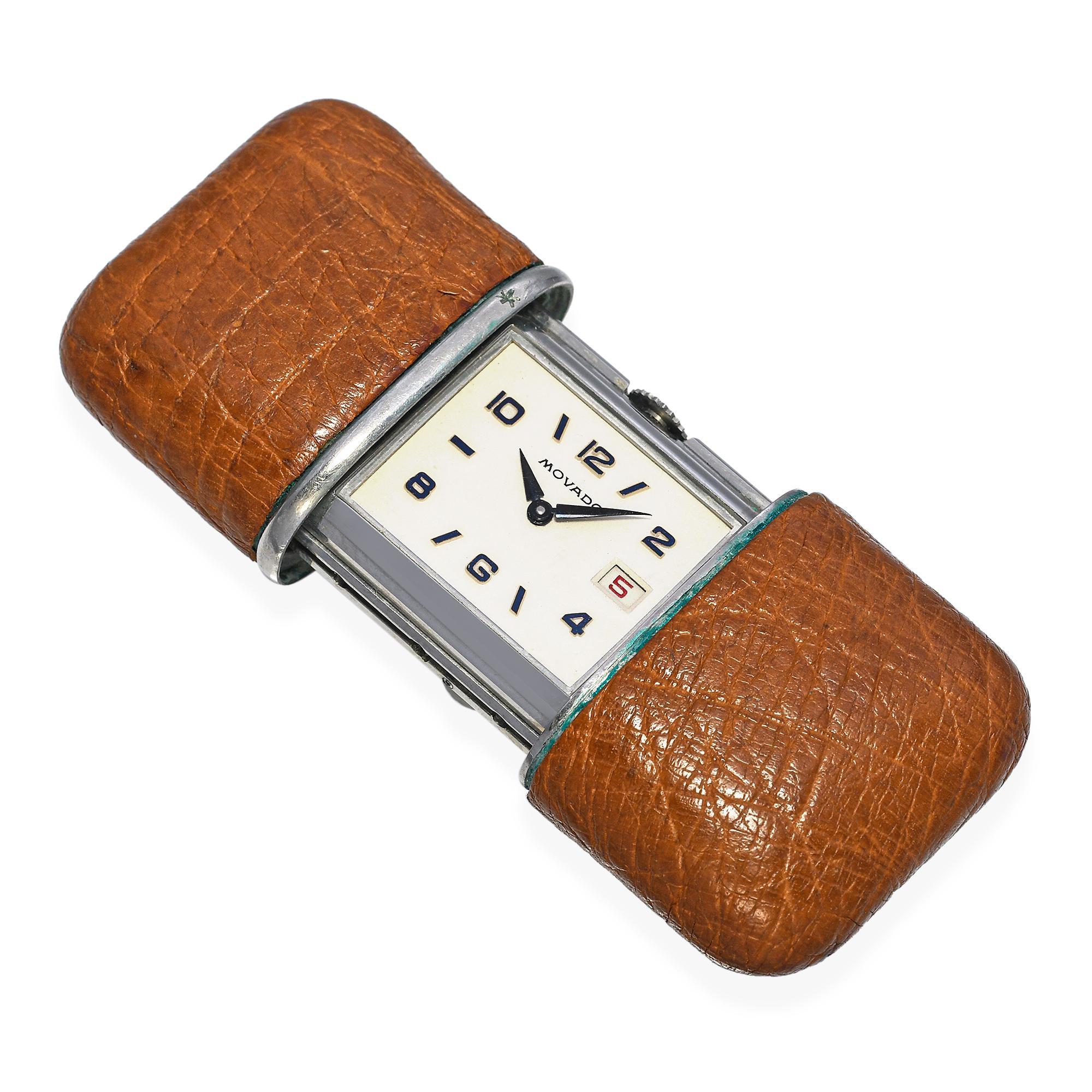 Este elegante reloj de viaje Movado Ermeto es un buen ejemplo del ingenio suizo y del diseño de la era Art Déco. Con una caja de acero inoxidable envuelta en su original revestimiento de piel, el diseño compacto se enrolla solo al abrir y cerrar la