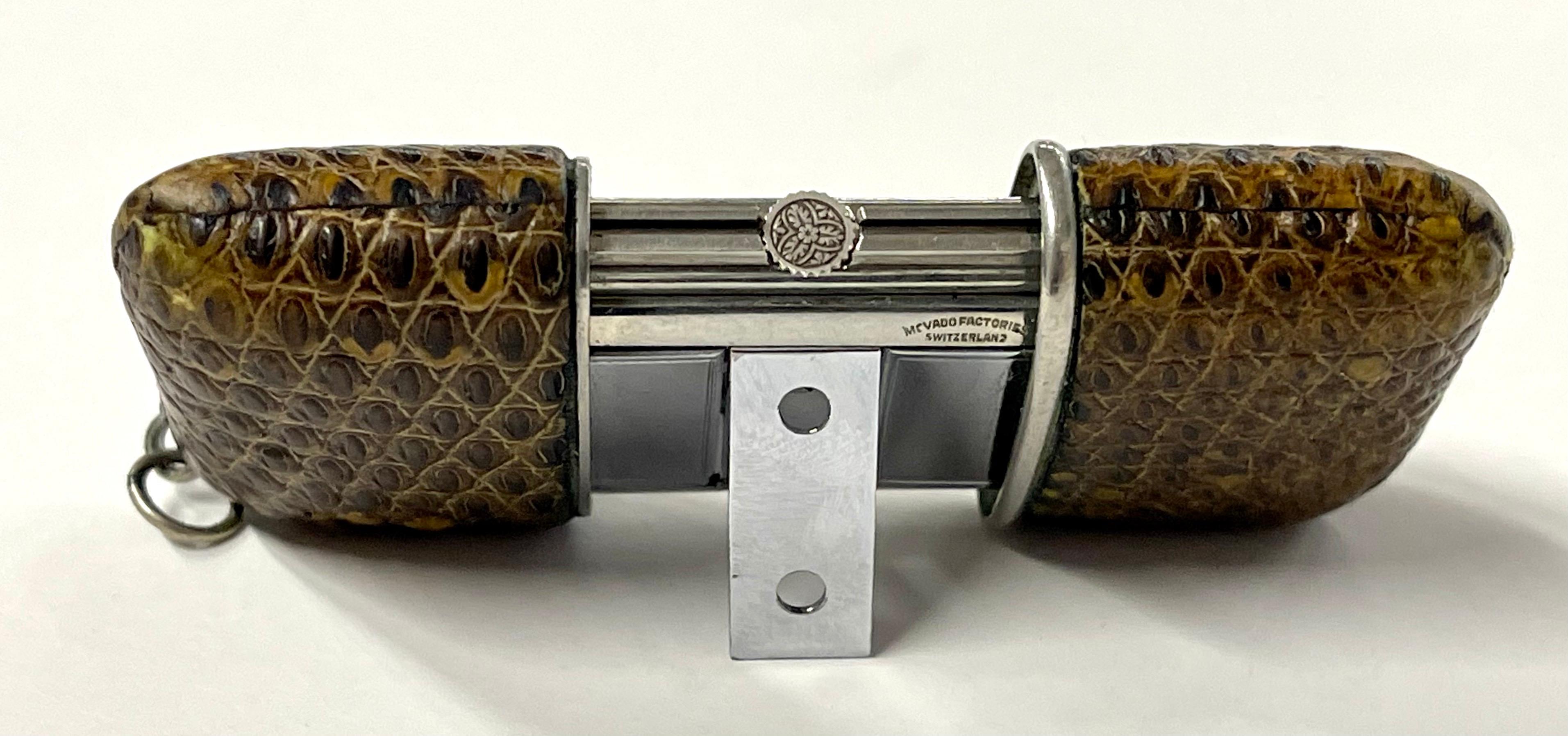 Une jolie horloge de voyage Movado Ermeto avec un boîtier recouvert de peau de lézard. En état de marche, le mouvement est remonté en ouvrant et en fermant le boîtier, en le faisant glisser pour l'ouvrir et le fermer. L'heure est réglée en soulevant