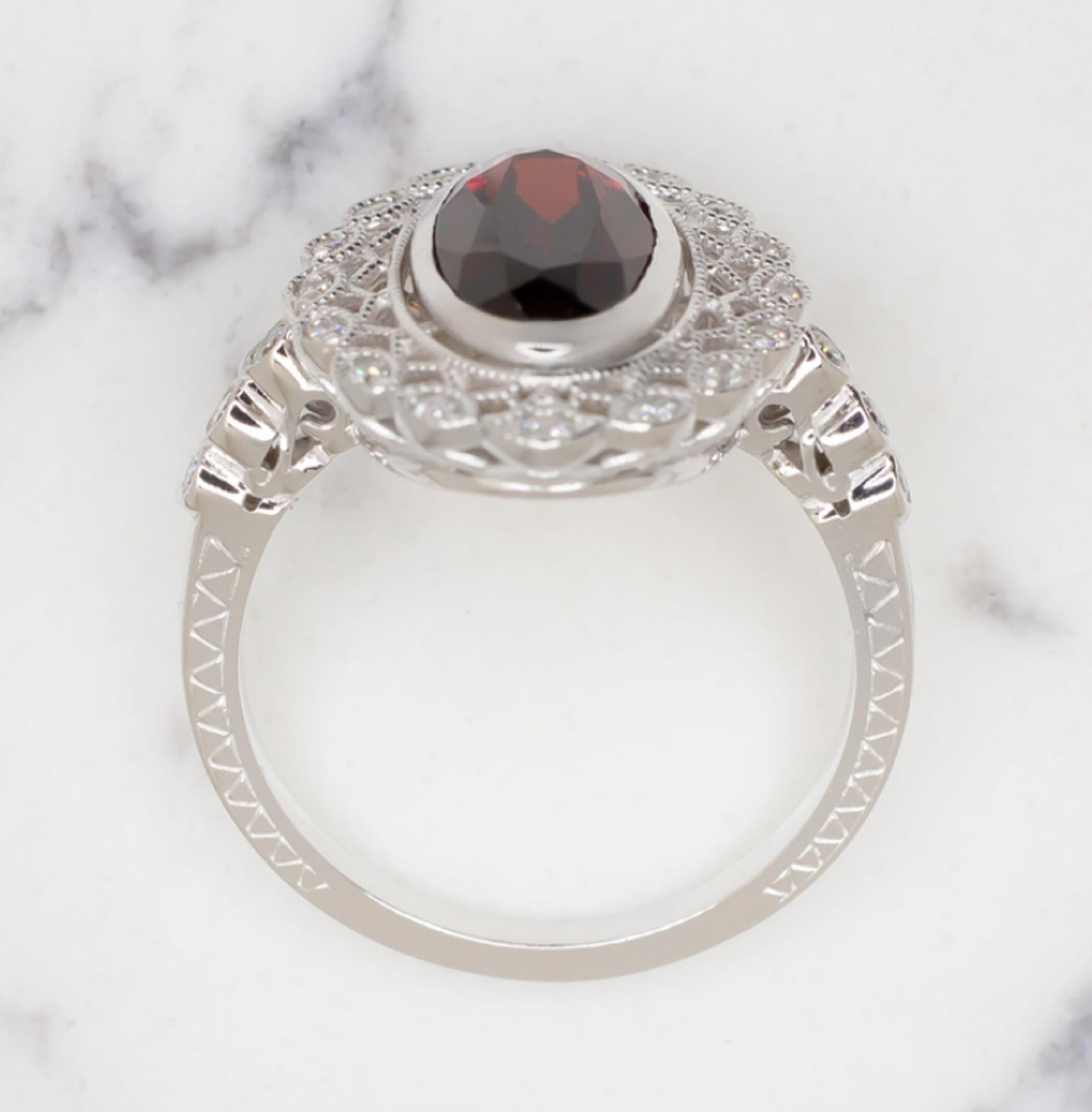 This stunning garnet and diamond ring is positively gleaming with eye catching sparkle and rich color! The 2.5ct (approximate) garnet is a gorgeous rich red hue, and it has a beautiful play of light! It stands out strikingly against the bright white