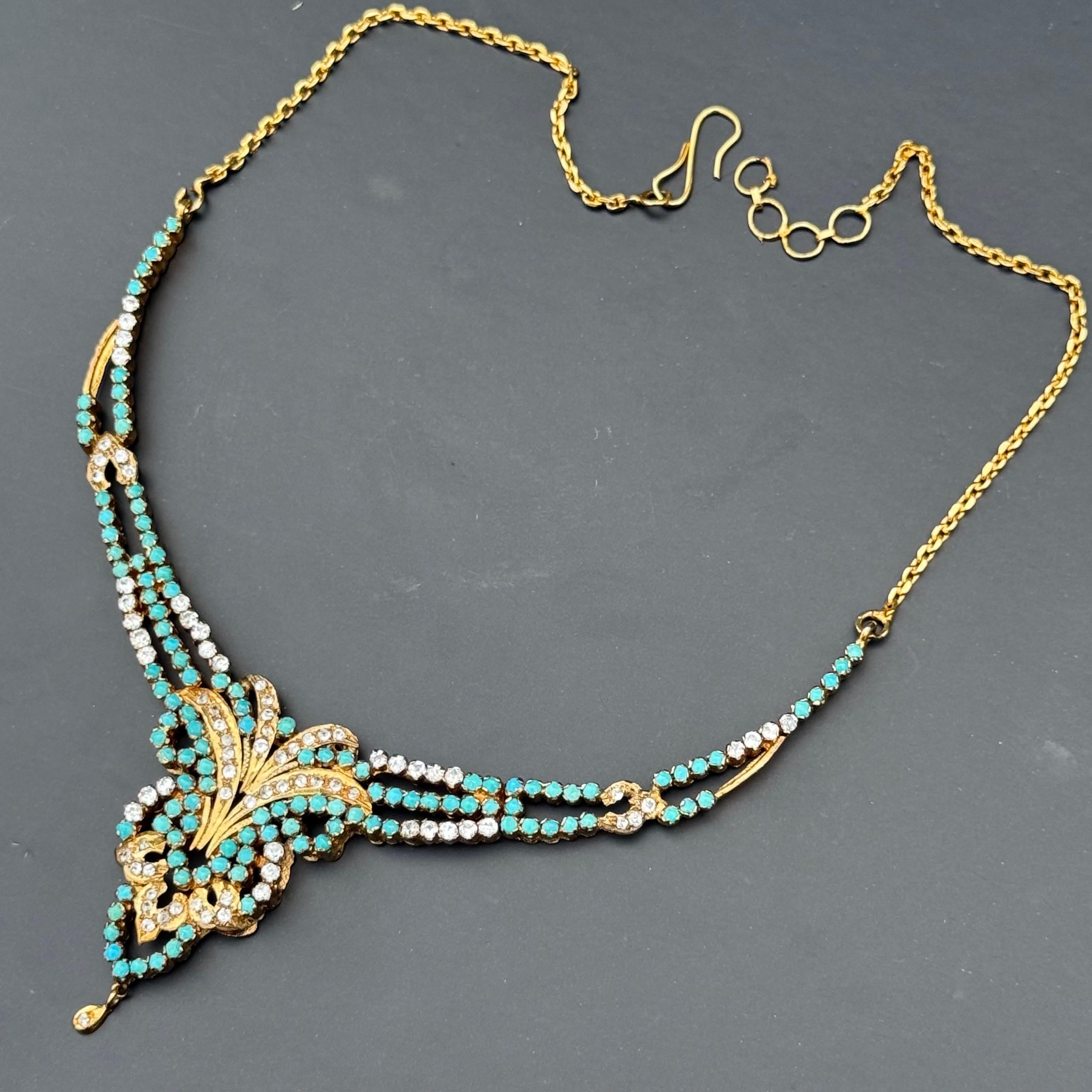 Questa collana a girocollo, realizzata a mano, evoca l'opulenza dell'estetica vittoriana e moghul, ed è riccamente impreziosita e dal taglio drammatico. La parte anteriore mostra una sontuosa disposizione di cabochon di turchese persiano
