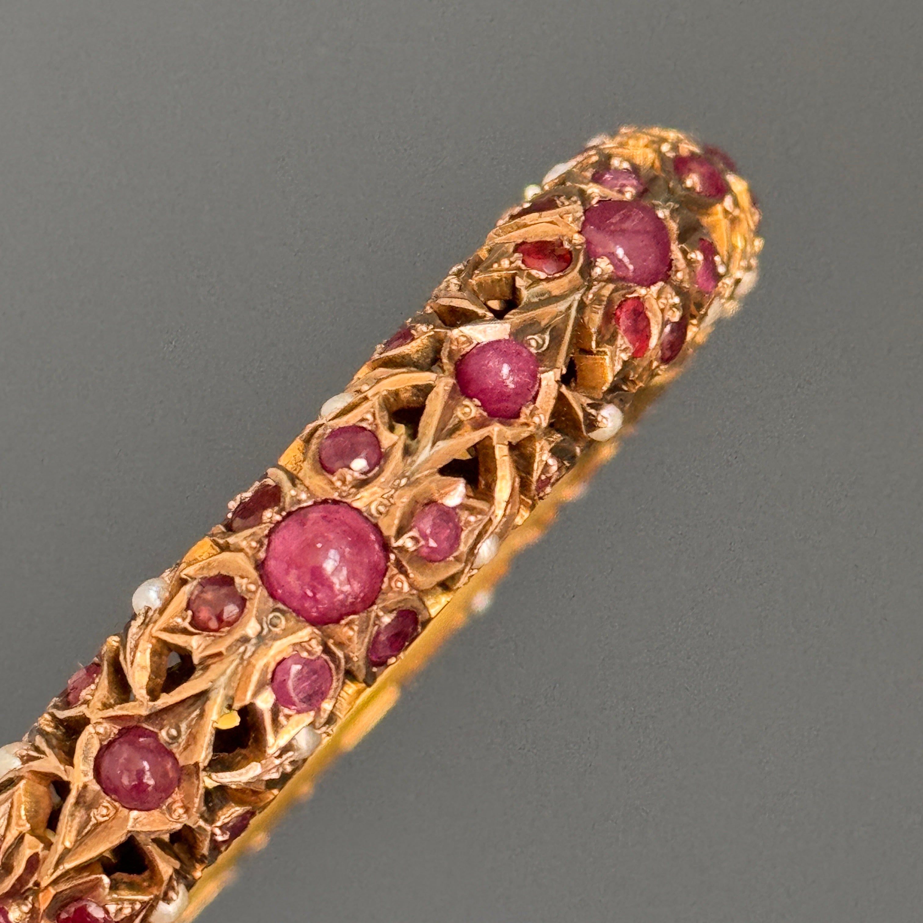 Dieser Vintage-Armreif mit Scharnier ist ein exquisites Beispiel für die Handwerkskunst der Moguln und ein wirklich bemerkenswertes Schmuckstück. Das sorgfältig aus 6 Karat Gelbgold gefertigte Schmuckstück weist ein kompliziertes, durchbrochenes