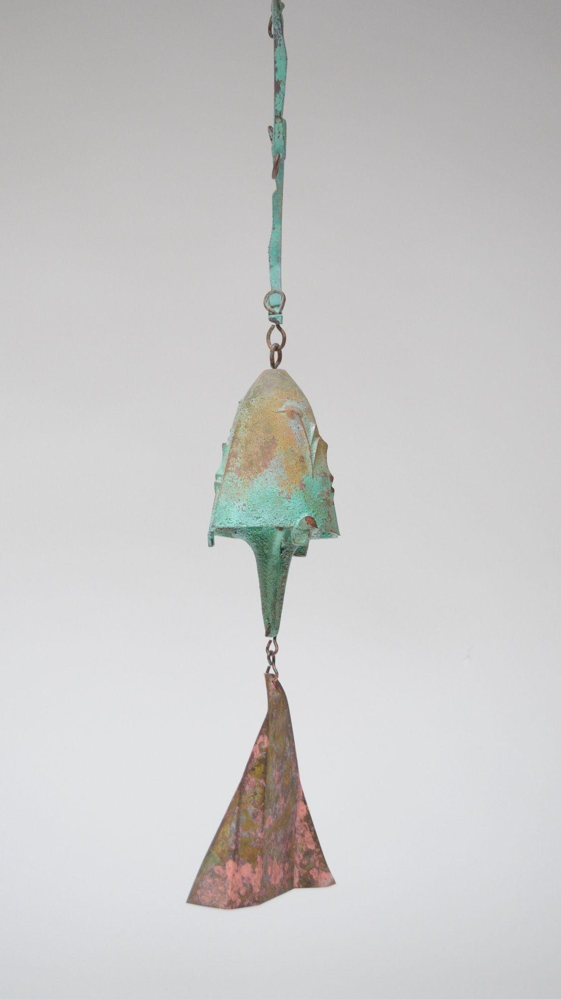 Windspiel/Glocke des Architekten Paolo Soleri für Arconsanti (die von ihm entworfene und 1970 erbaute Stadt in Arizona).
Gusselemente aus Bronze mit Grünspanpatina und mehrfarbig pigmentierter Glocke und dreieckiger Flosse.
Produktion Ende der
