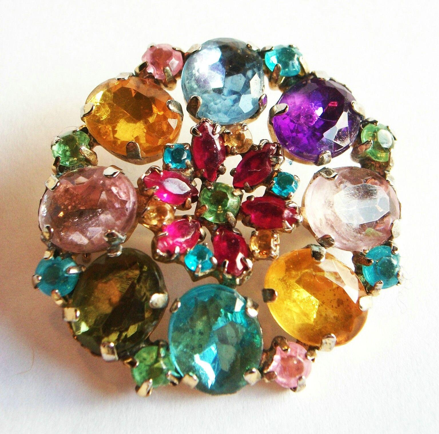 Vintage gold tone brooch set with various shapes, sizes and colors of rhinestones - original hinged pin to the back - unsigned - circa 1950's.

Excellent vintage condition - no loss - no damage - no repairs - sturdy pin and closure - minor