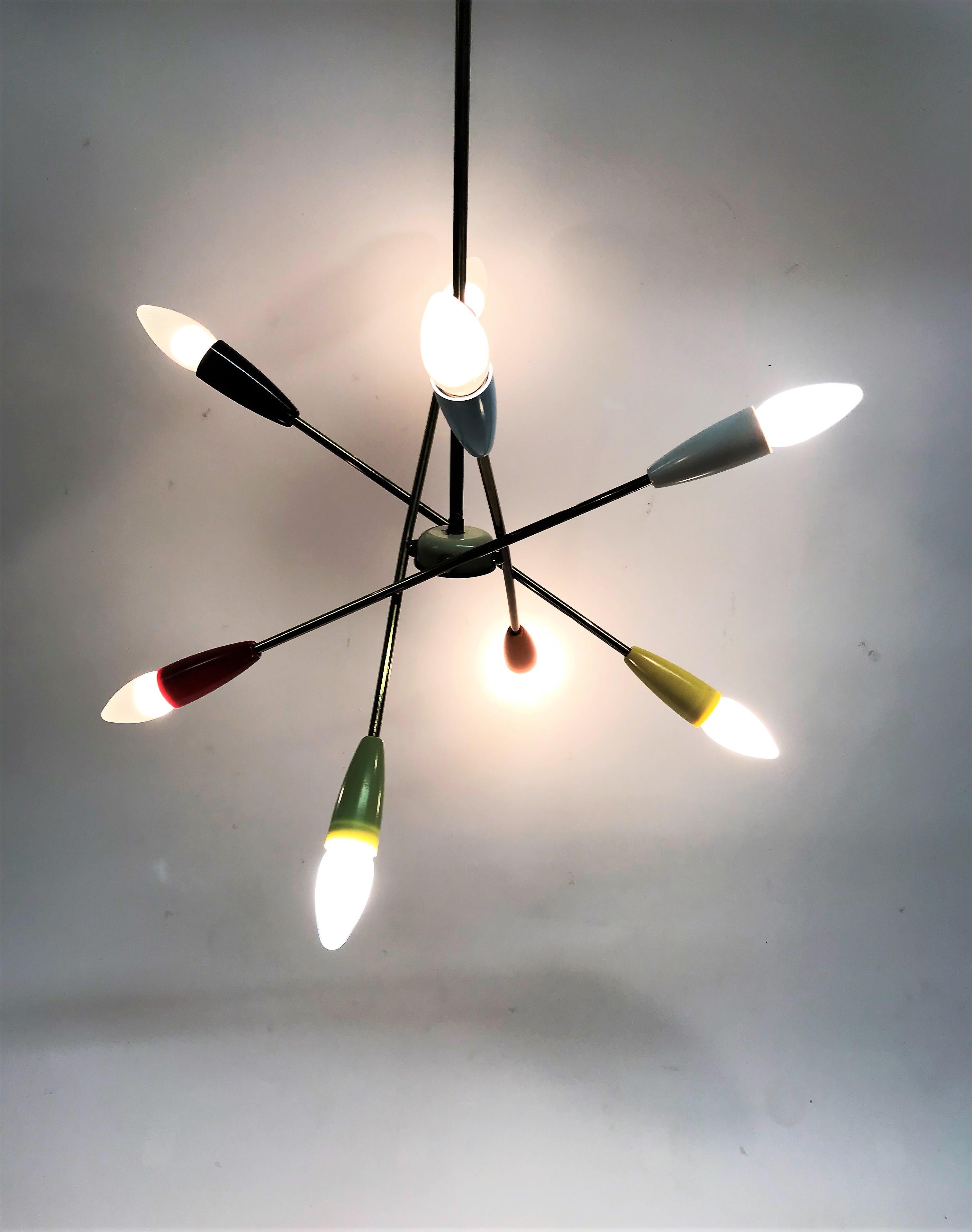 Coloured sputnik chandelier with 8 lightpoints.

The chandelier consists of 4 adjustable brass arms each having two lightpoints.

Beautiful original condition, the plastic shades are in good condition and do not have any melting marks or other