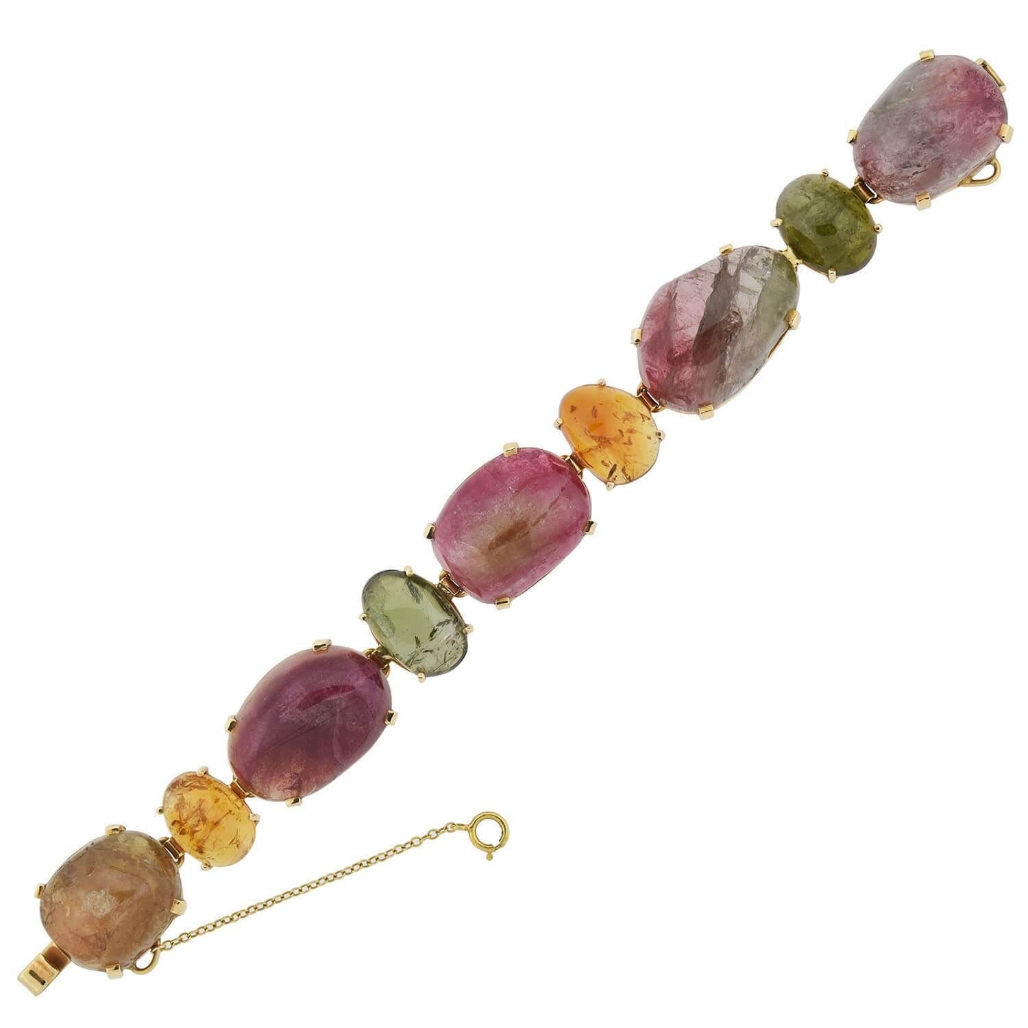 An incredible and unique Vintage multi-colored tourmaline link Maine bracelet from the 1950s era! This bold piece features 9 substantial natural stone links that rest in a 14kt yellow gold setting, each one connected together to create a straight