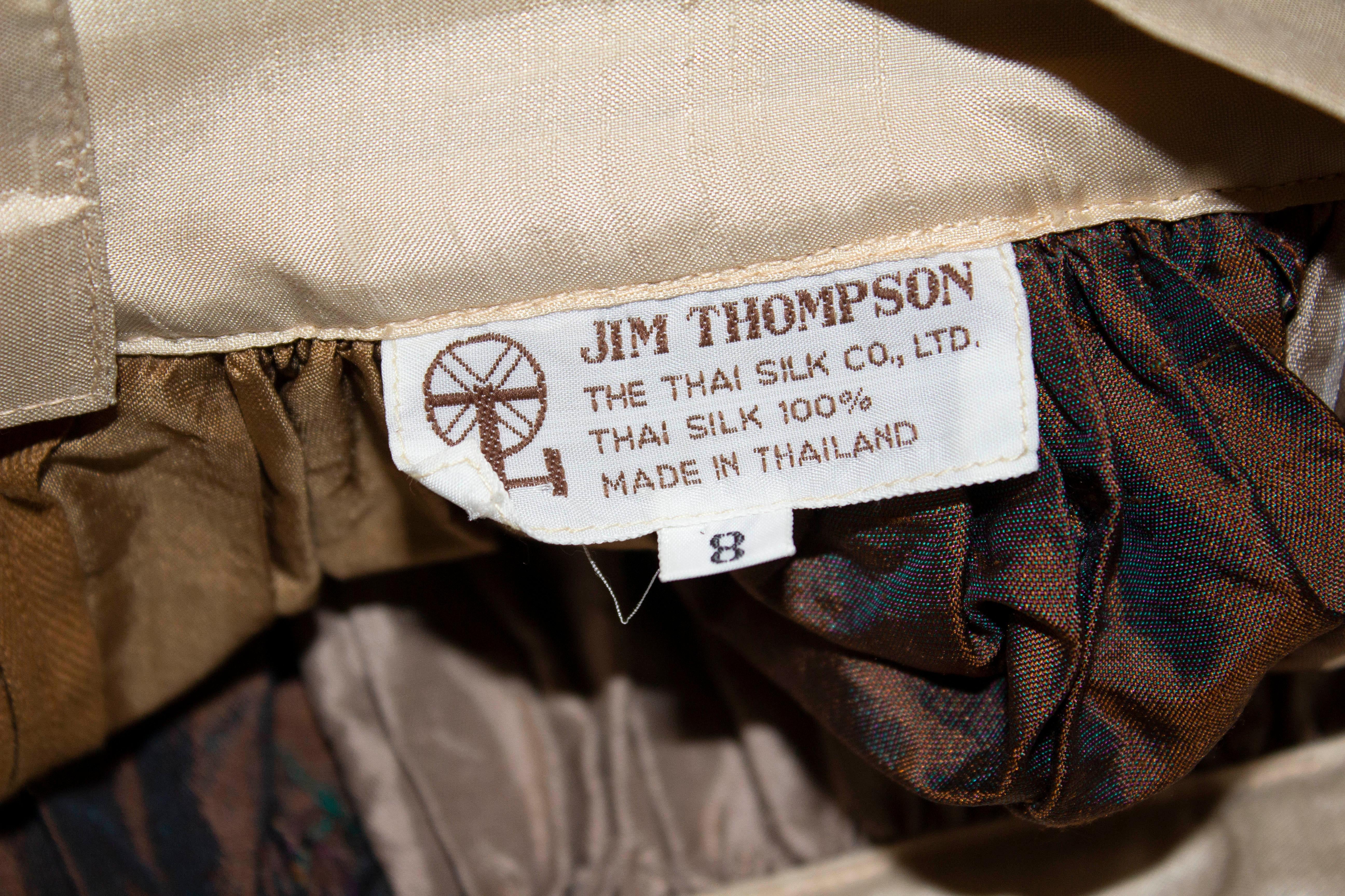 A wonderful headturning vintage silk skirt by Jim Thompson. In various shades of gold and brown , the skirt has gathering at the waist and a central back zip. It is marked size 8 and  is unlined.  Waistband 2'' depth, waist 28'',length 43''