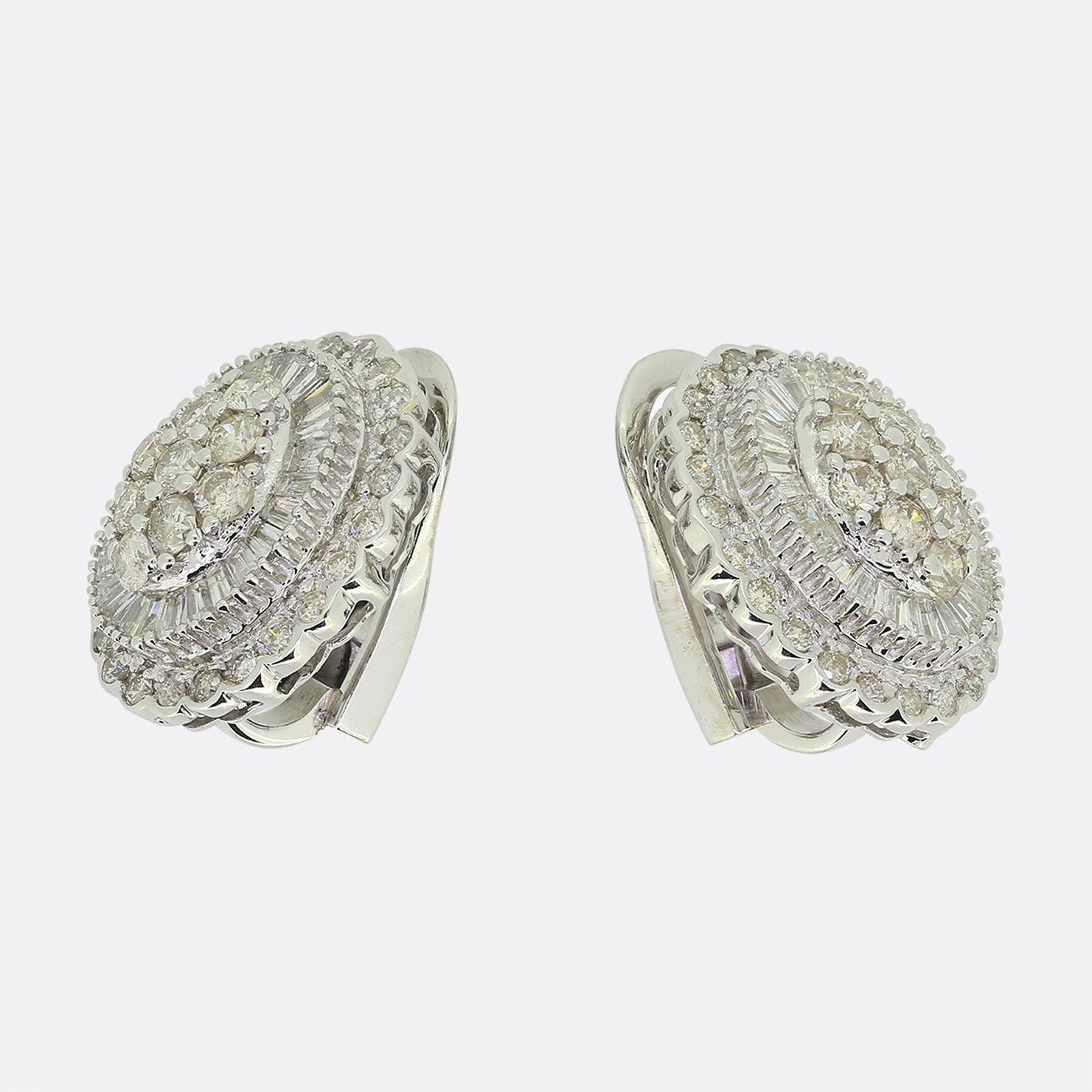Here we have an scintillating pair of diamond cluster earrings. Each earring has been crafted from 18ct white gold with both pieces identically playing host to three layers of diamonds. The first layer showcases 9 round brilliant cut diamonds; all