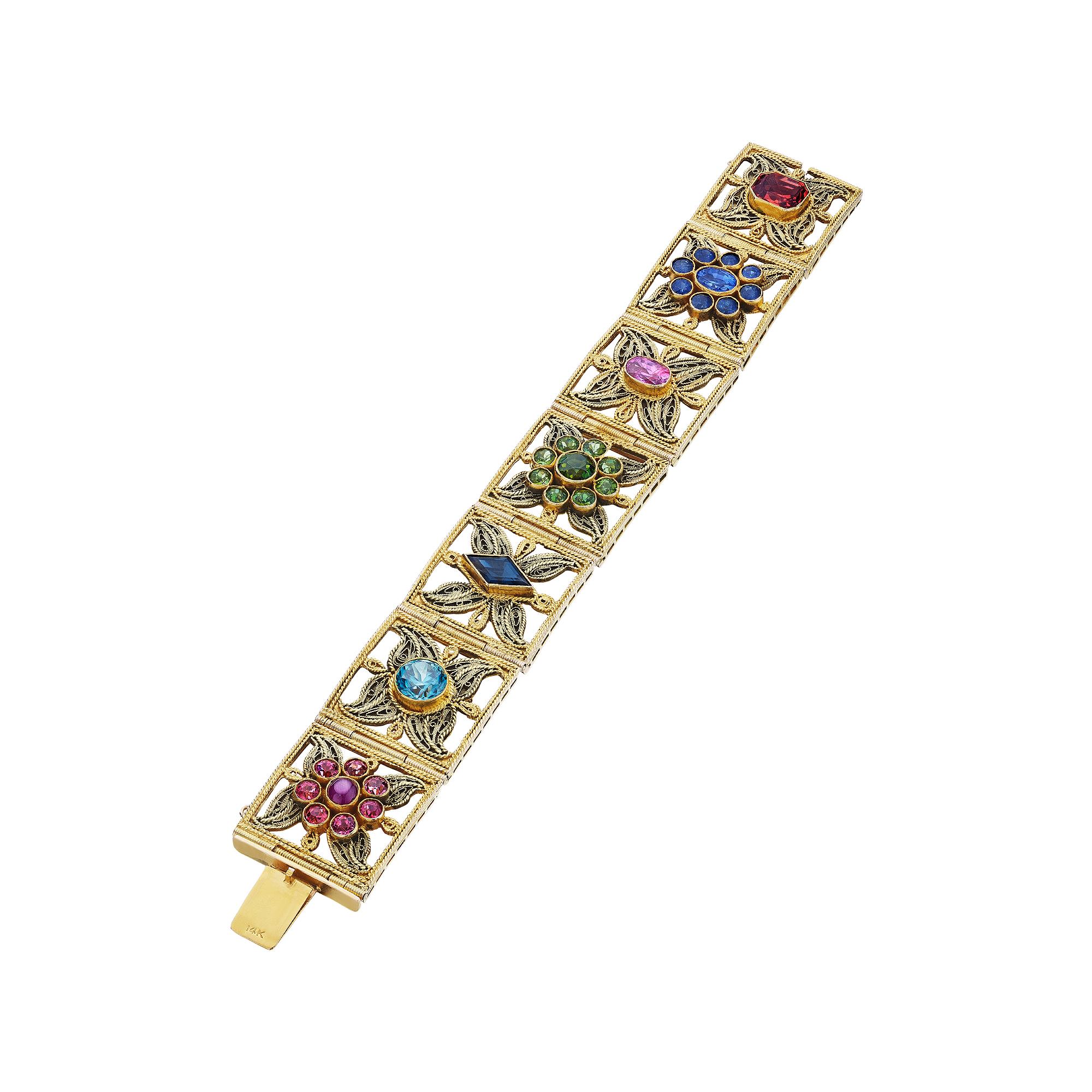 Reminiscent of a handmade one-of-a-kind Old World embroidered passementerie trim, this incredible gemstone and gold vintage bracelet looks as as though it was woven on a magical spinning wheel.  Designed with seven spun gold squares, each depicting