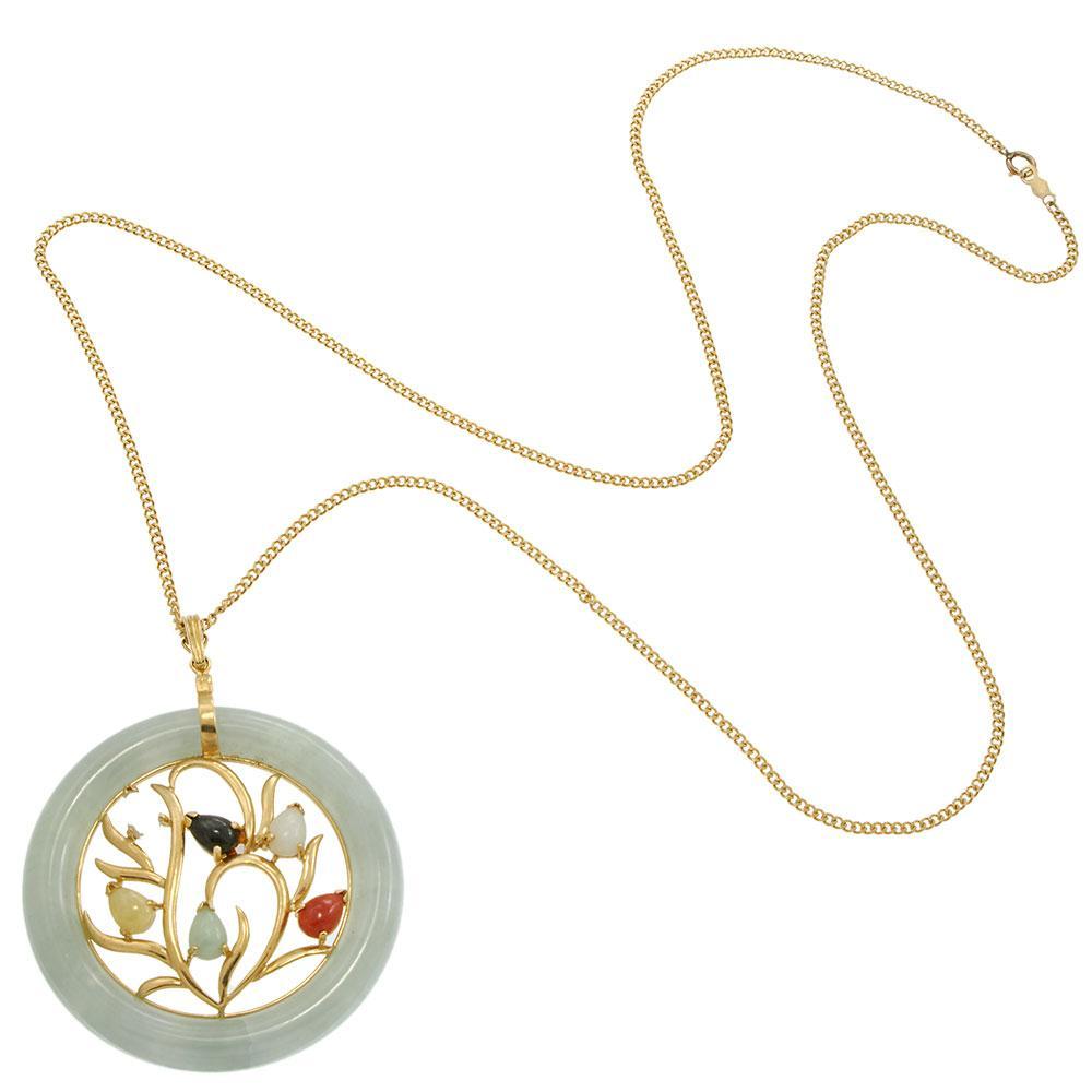 Trésor vintage qui célèbre l'art et la beauté naturelle, ce pendentif est réalisé en or jaune 14KT avec un motif floral ouvert. La monture circulaire en jade renferme six pierres de jade multicolores en forme de poire, chacune sertie d'une feuille,