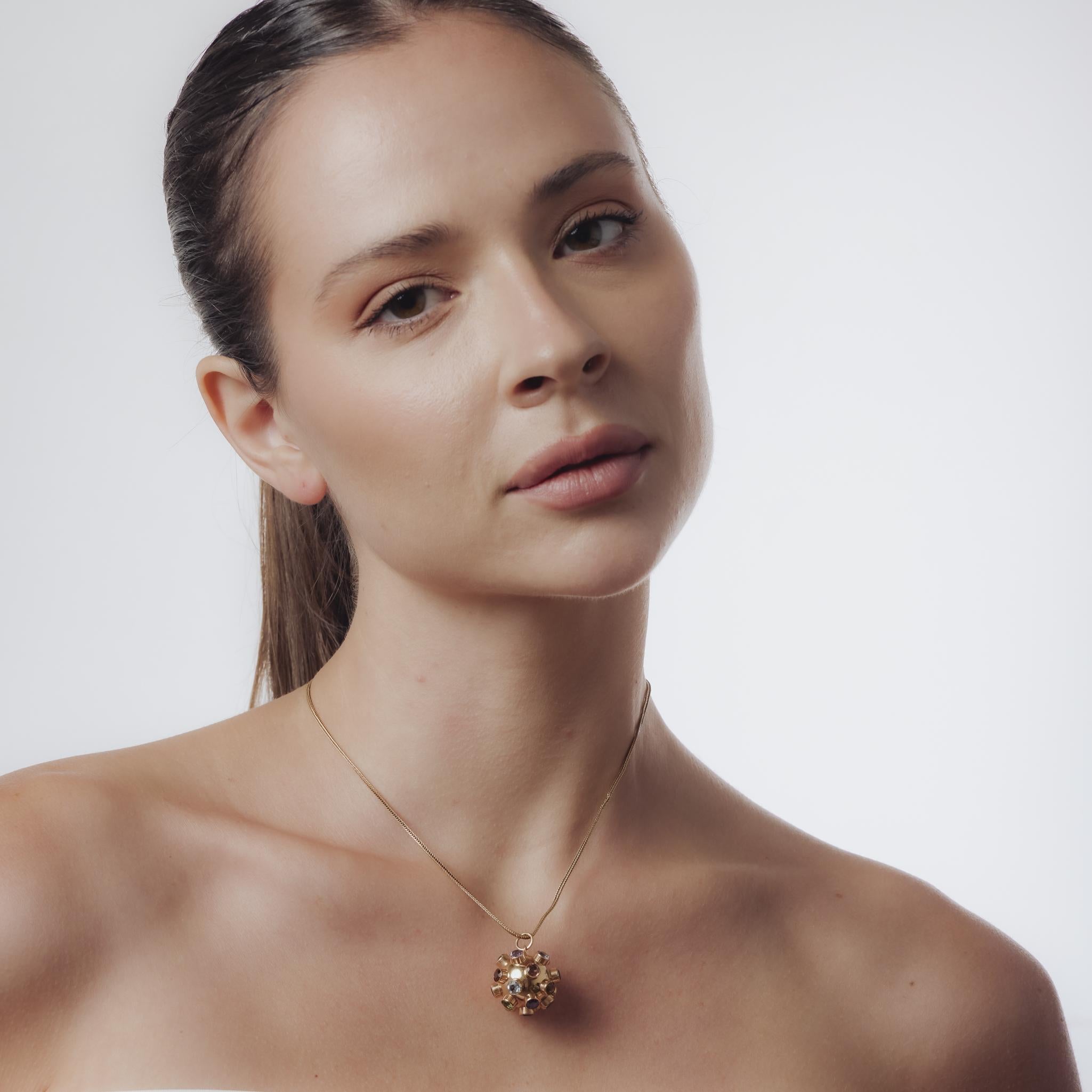 Ce collier vintage des années 1980 est réalisé en or rose et jaune 14k et présente un mélange vibrant de pierres précieuses rondes, dont l'améthyste, l'aigue-marine, le péridot, la topaze, la tourmaline et la rubellite, chacune mesurant environ 4,15