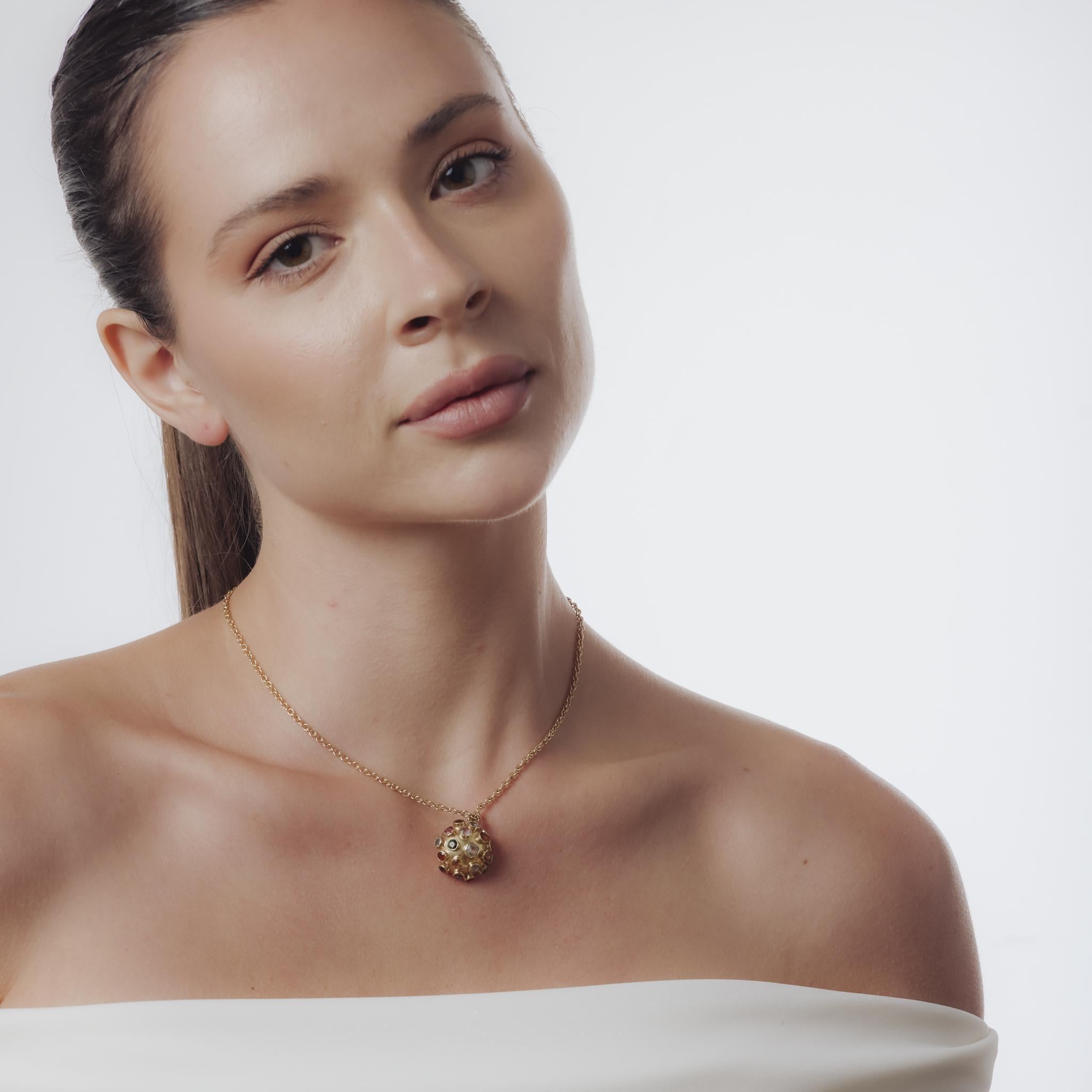 Ce collier vintage des années 1980 est composé d'un pendentif en or jaune 18k suspendu à une chaîne en or jaune 14k. Présentant un mélange vibrant d'améthyste, d'aigue-marine, de péridot, de topaze, de tourmaline et de citrine de taille ronde,