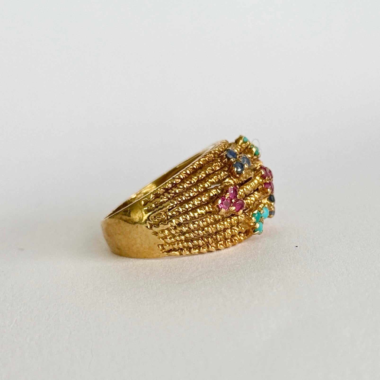 Questo elegante anello contiene turchesi, zaffiri e rubini. L'oro ha un effetto a corda e le pietre sono incastonate in collezioni da 3.

Misura dell'anello: N o 6 3/4
Larghezza della banda: 14 mm

Peso: 9.2 g