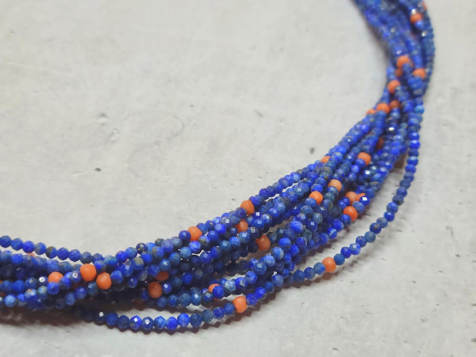 Wir präsentieren eine atemberaubende 12-strängige Perlenkette aus natürlichem afghanischem Lapislazuli und natürlicher italienischer Mittelmeerkoralle im Vintage-Stil. Die facettierten Lapislazuli-Perlen bieten einen Überfluss an blauen Farbtönen,