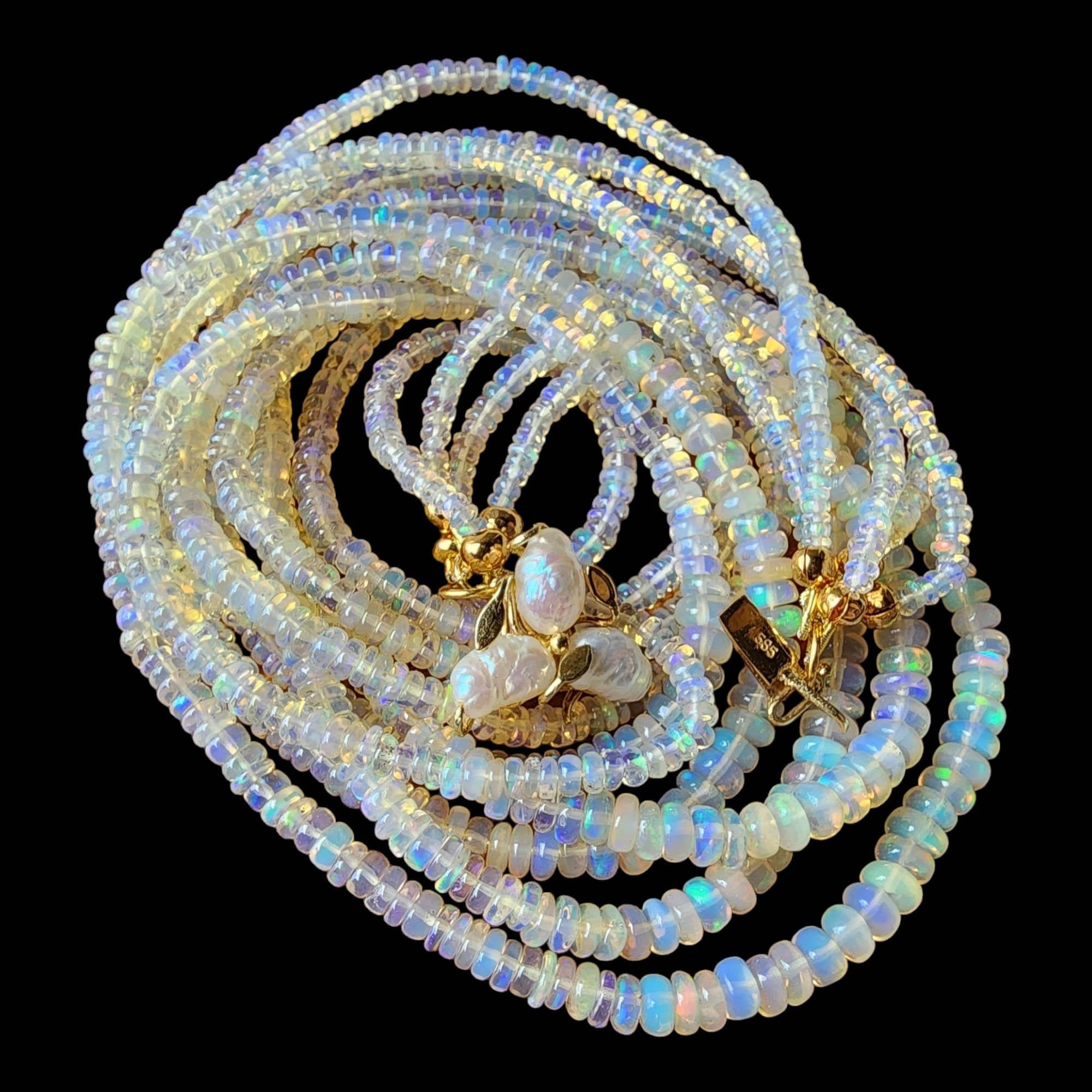 Werten Sie Ihre Schmucksammlung mit dieser exquisiten mehrreihigen Opalperlenkette auf. Jeder der fünf luxuriösen Stränge ist kunstvoll mit schimmernden Opalperlen verziert. Das Design wird durch die Hinzufügung von leuchtenden goldenen Perlen