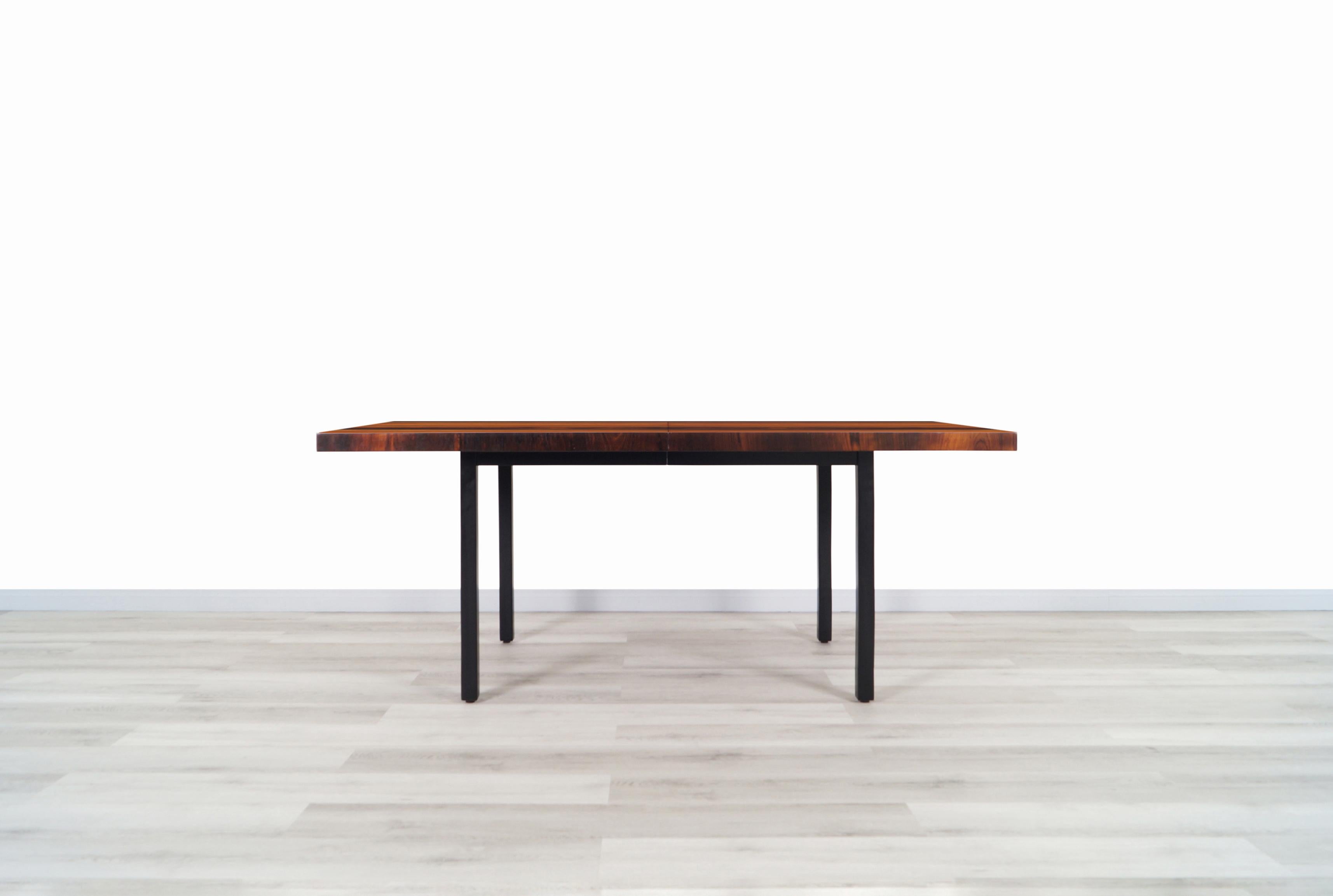Magnificent vintage expanding dining table designed by Milo Baughman for Directional in the United States, circa 1960s. This spectacular and organic design features a mix of quality woods such as rosewood, walnut, and oak, creating a seamless