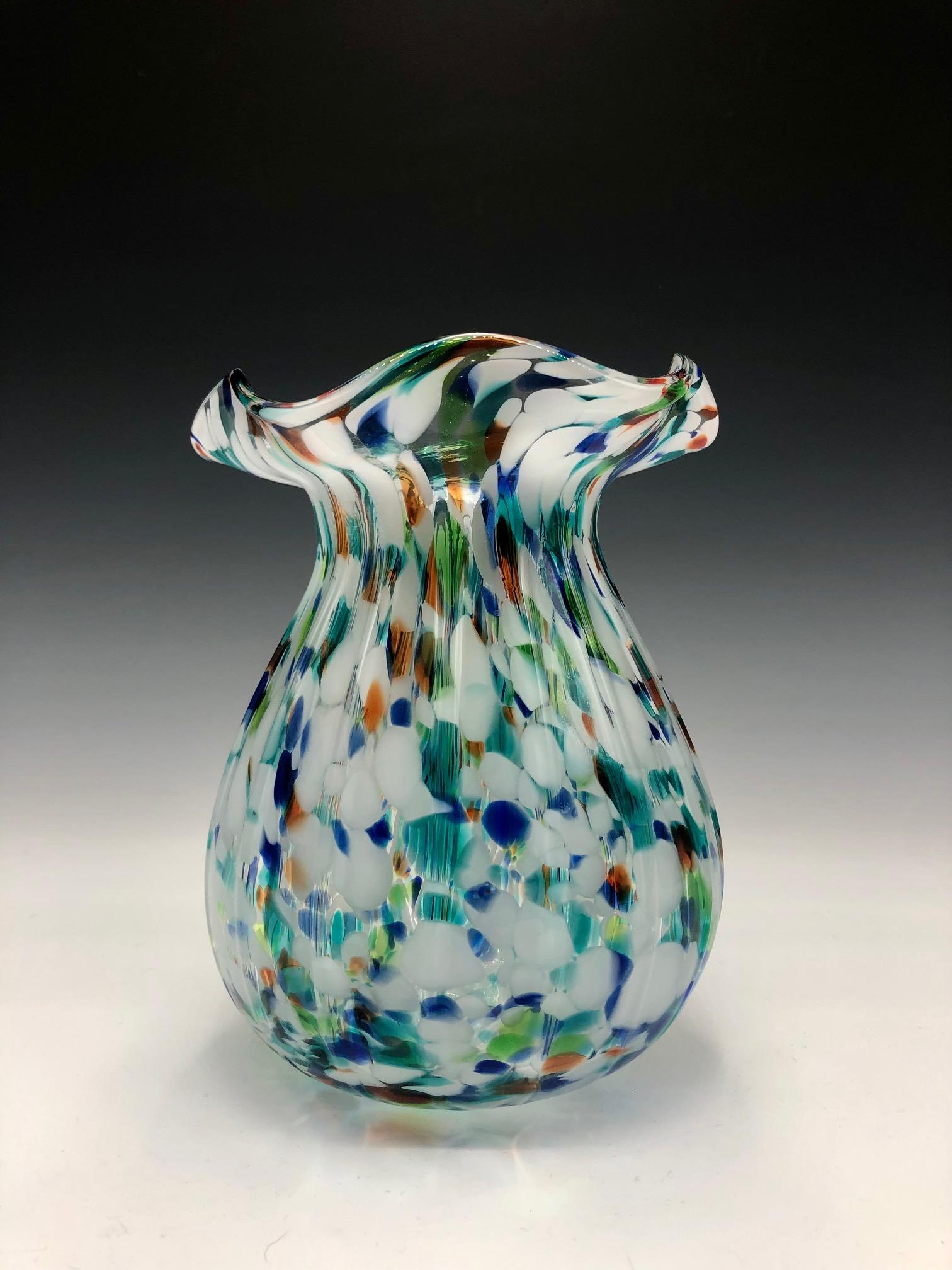 Elegant vase en verre d'art multicolore de style Murano des années 1970 en forme d'ampoule avec un col cintré et un dessus à volants. 

Une belle pièce moderne et colorée. 

Excellent état vintage. Pas d'ébréchures ni de fissures.

Murano glass, art