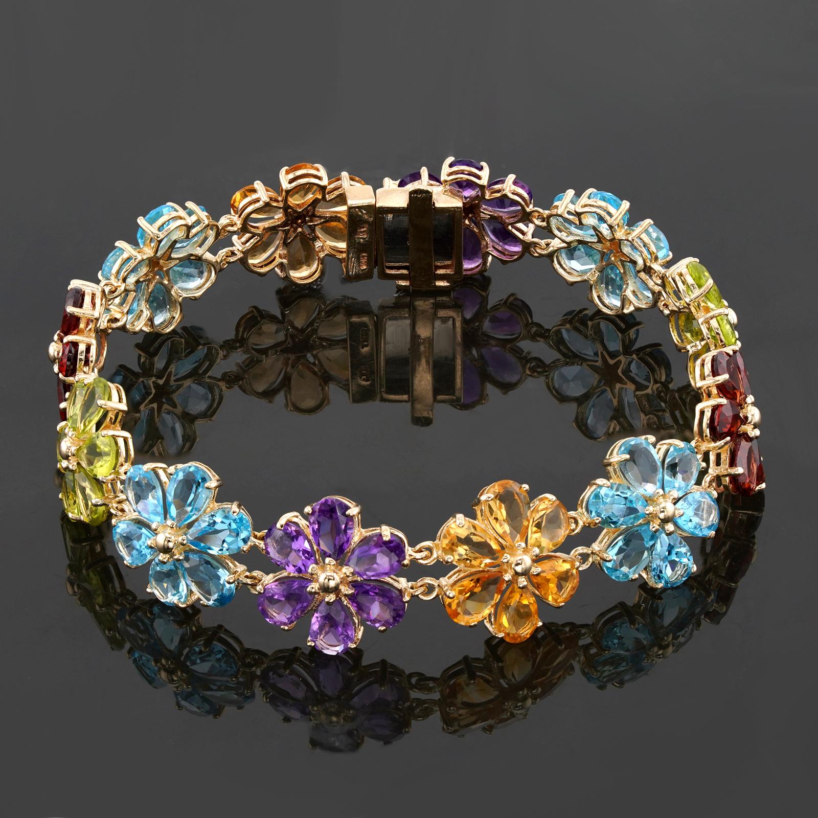 This fabulous vintage bracelet features 6-petal flower-shaped links crafted in 18k yellow gold and set with genuine faceted pear-cut gemstones - amethyst, garnet, peridot, and topaz. Made in United States circa 1980s. Measurements: 0.55