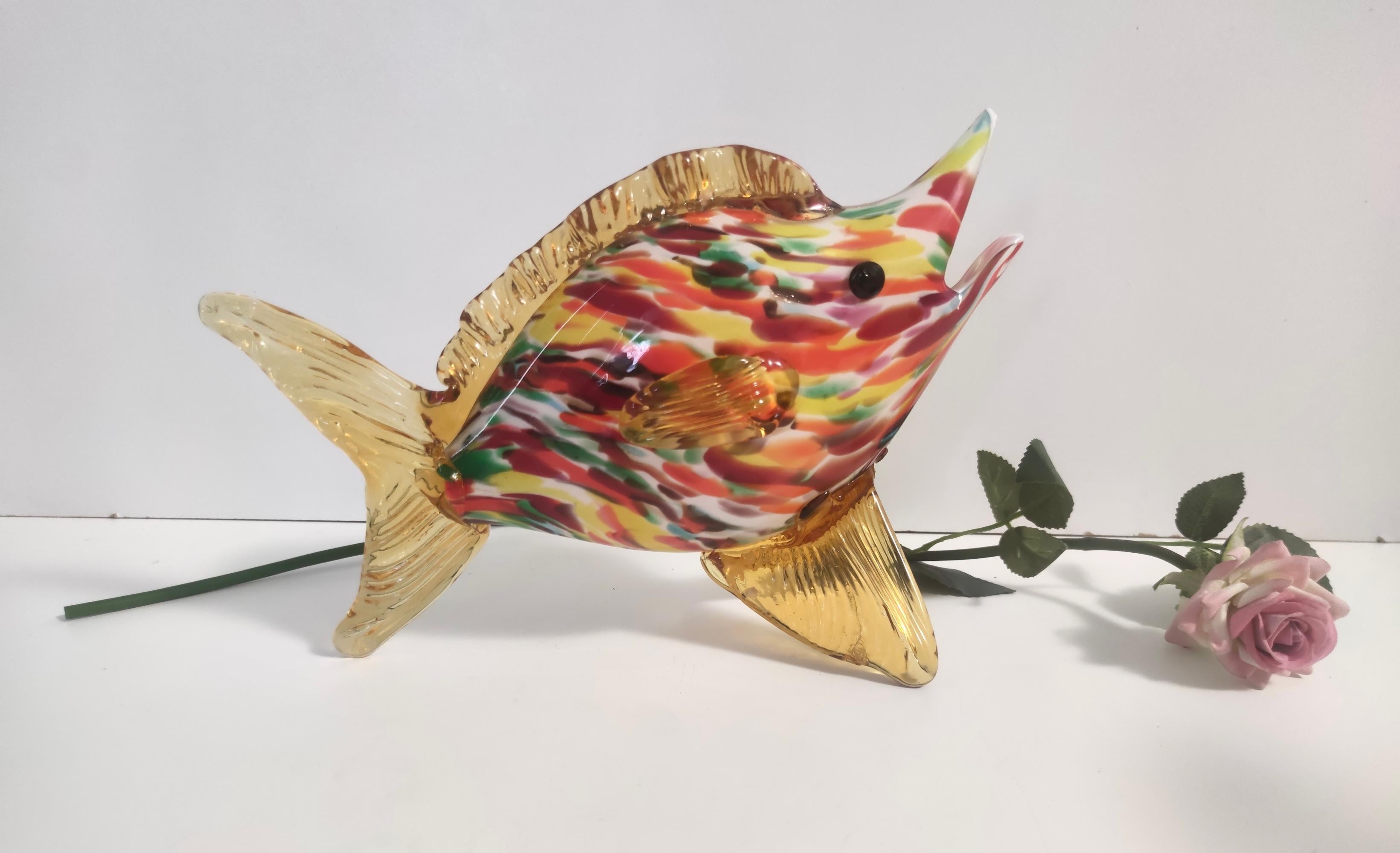 Murano, Italie, années 1950. 
Ce poisson est réalisé en verre de Murano soufflé à la main, encastré et polychromé, avec des nageoires en verre ambré modelé à la main. 
Il s'agit d'une pièce vintage, qui peut donc présenter de légères traces
