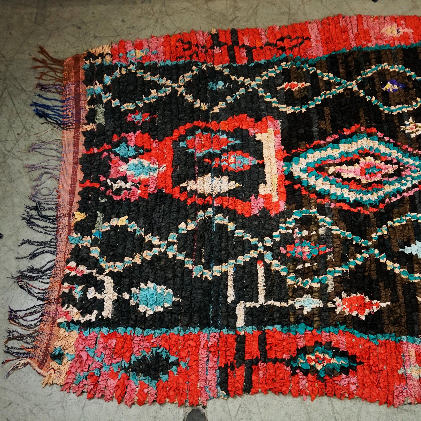 Charming Multicoloured Vintage Berber Moroccan Boucherouite rug with boho chic tribal style. This hand-knotted wool vintage Berber Moroccan rug features nearly Black and strong colours like red orange, turquoise, yellow, rose and creme white.
Though