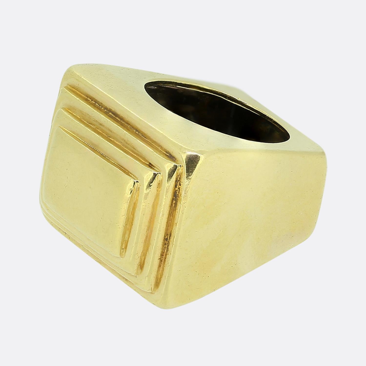 Hier haben wir einen gewagten Kleiderring aus 18 Karat Gelbgold. Das Design zeichnet sich durch eine markante rechteckige Fläche mit geschichteten geometrischen Details aus, die eine beeindruckende optische Tiefe erzeugen. Die Oberfläche des Rings