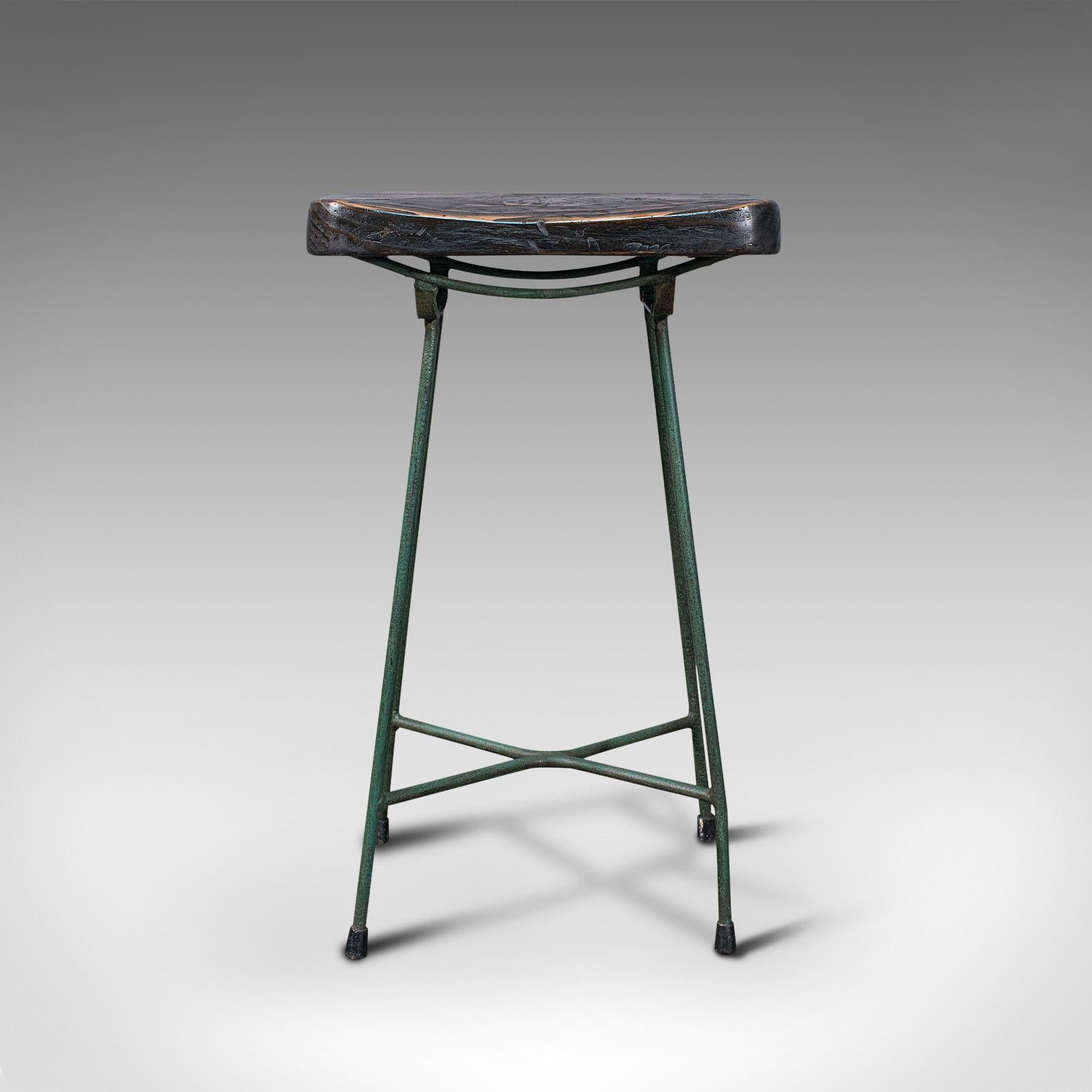 This is a vintage munitions factory stool. An English, pine and enamelled wrought iron legs in the industrial or laboratory taste, dating to the mid 20th century, circa 1940.

Pleasingly timeworn stool with charming appearance
Displays a