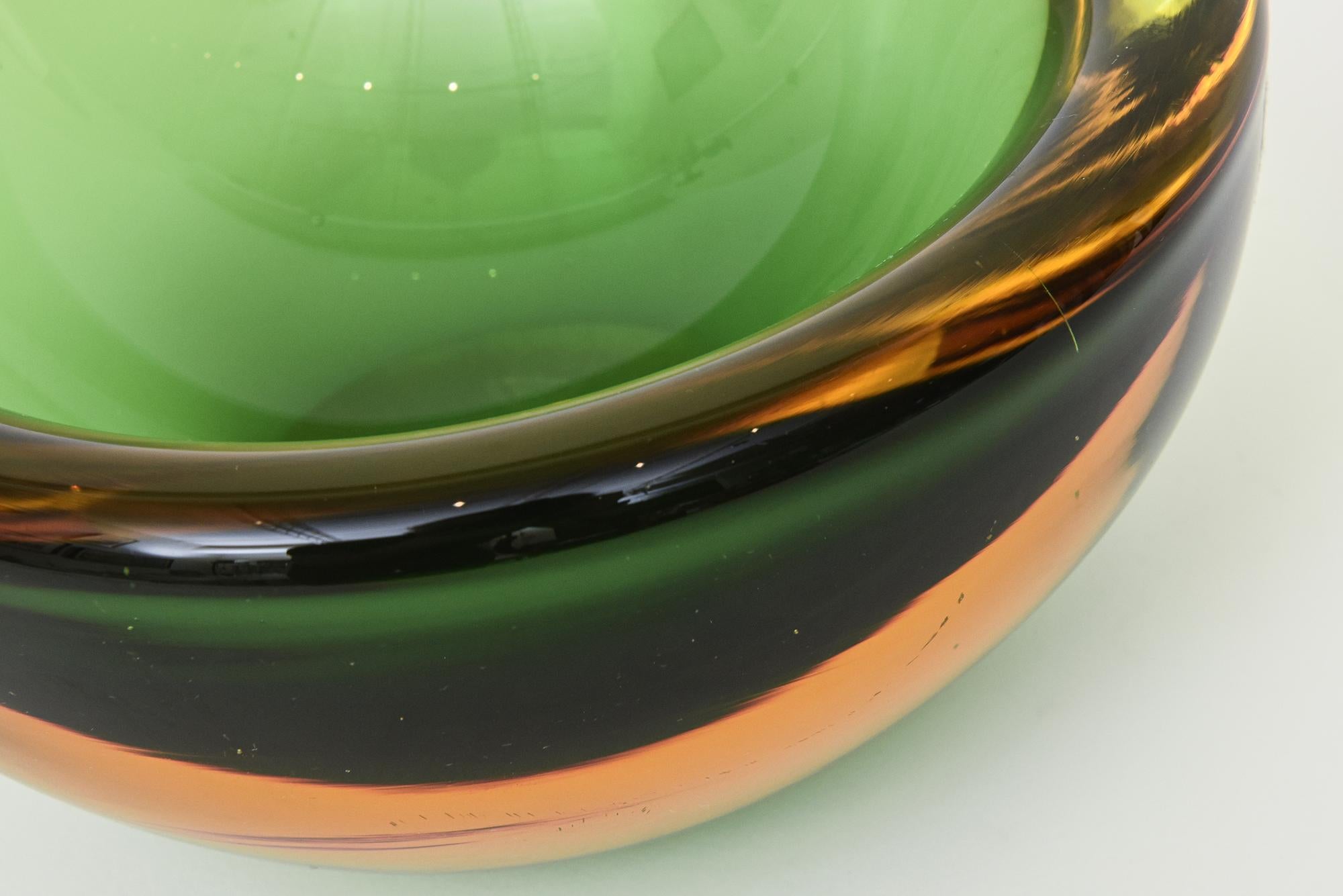 This vintage labeled Alessandro Mandruzzato Murano blown glass thick walled bowl is in sommerso form. It is a geode bowl that is large and heavy from the 70's. The colors range from shades of emerald and kelly and lighter green with colors of
