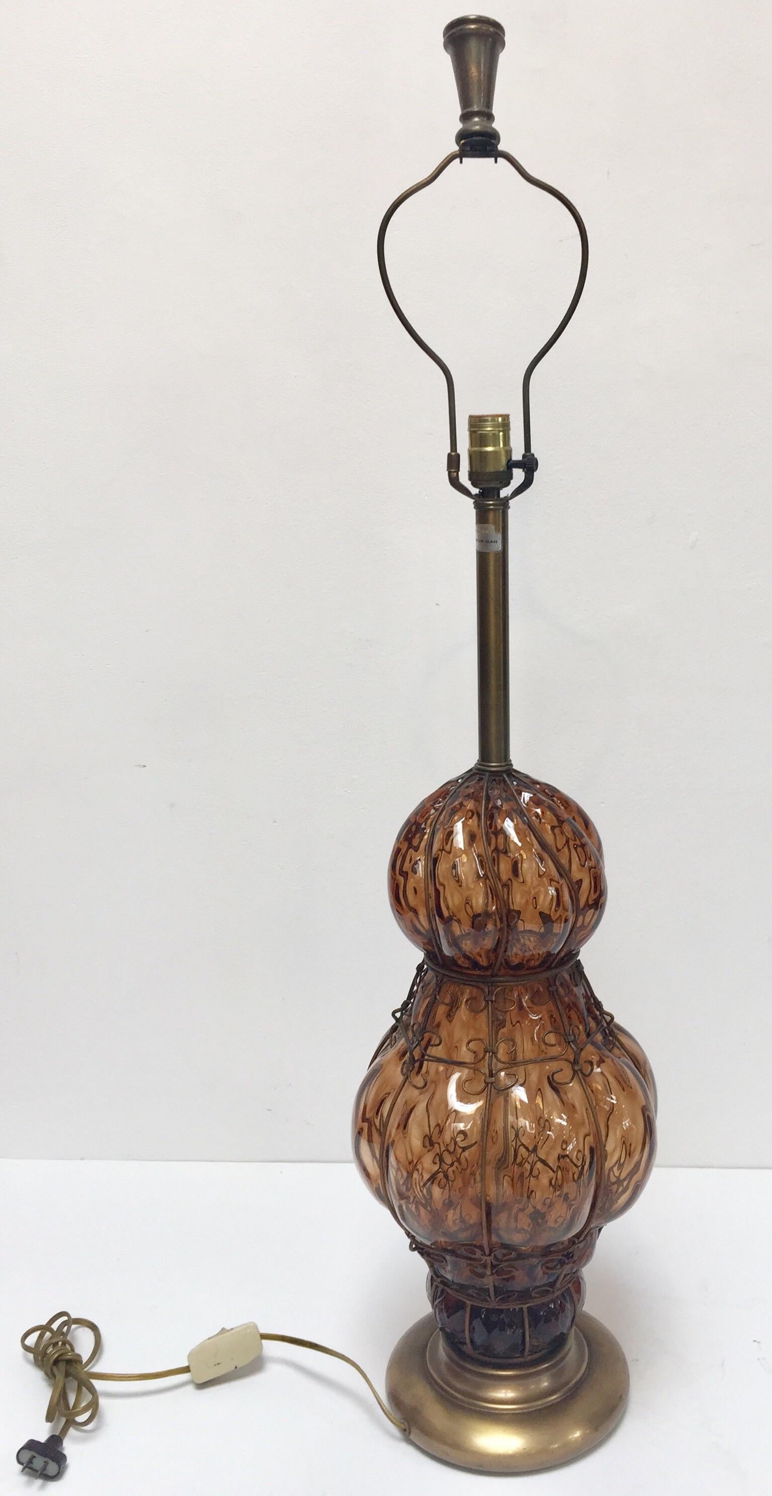 Lampe de table en verre ambré vénitien à bulles d'air de Murano, d'origine Marbro, datant du milieu du siècle dernier.
Verre soufflé à la main de style vénitien avec design de cage câblée en métal.
Mesures : Base de 9