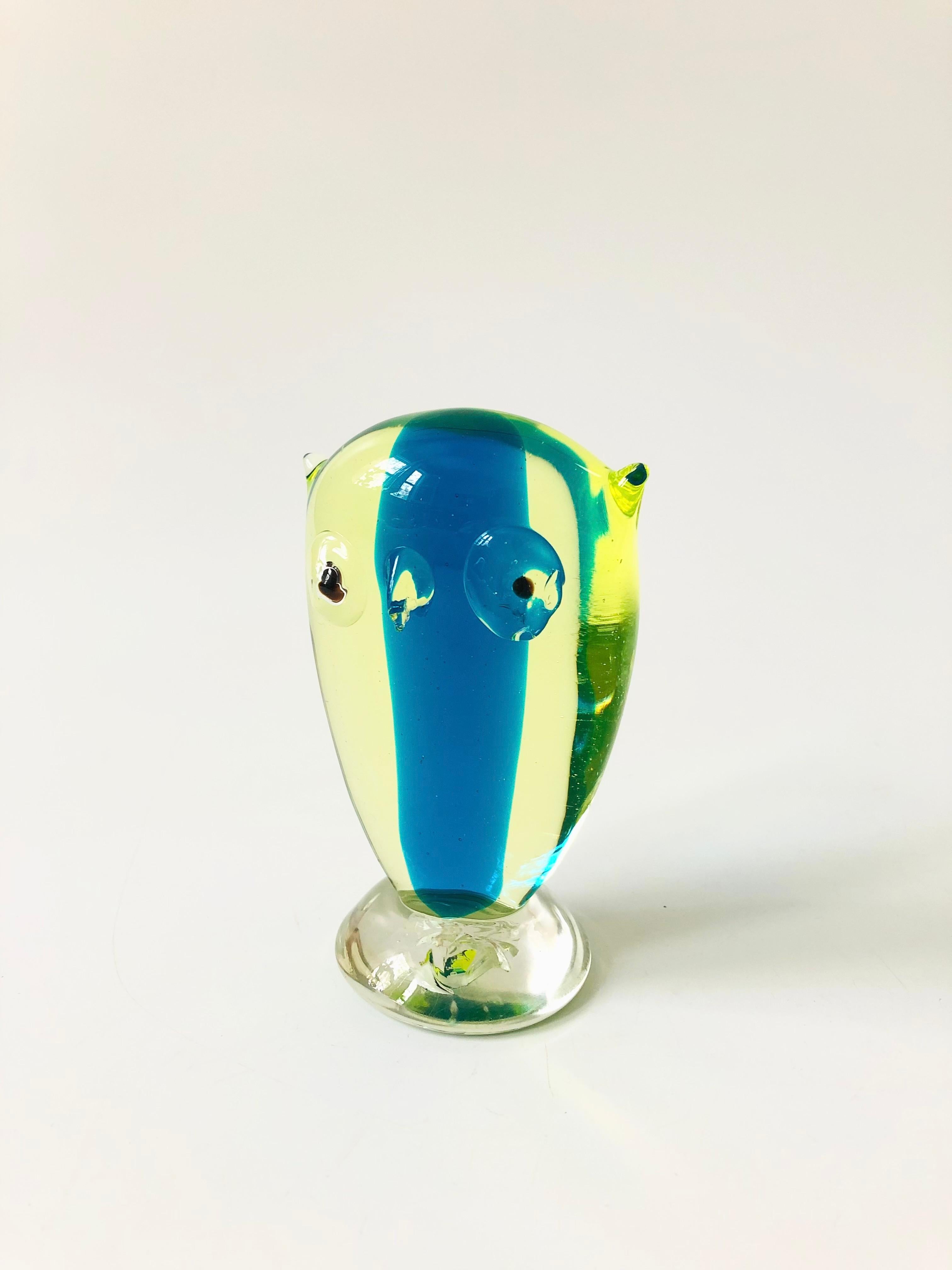 A mid century art glass owl by Murano. Nice stylized shape, made of tinted green glass with a stripe of vibrant blue down the center. No sticker or marking, though the form is known to be by Murano.
 