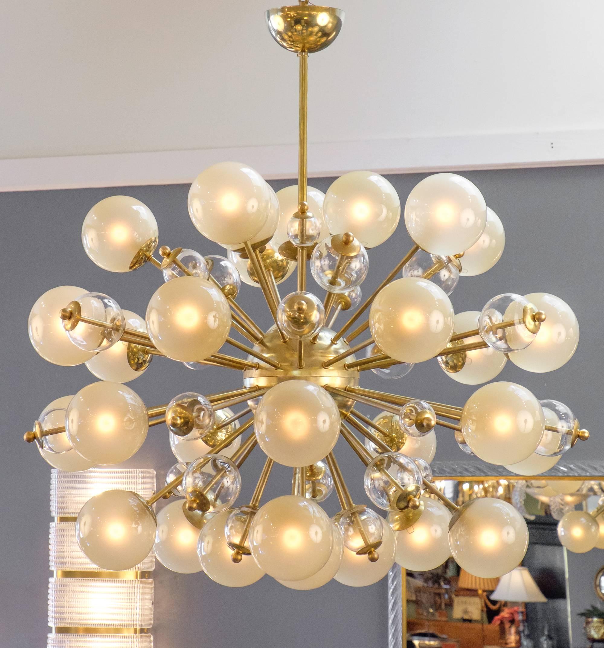 Ce grand lustre Sputnik vintage de Murano, avec ses globes de champagne, est une véritable célébration de la lumière. Cette pièce est dotée d'une structure en laiton qui supporte 30 ampoules en verre de Murano d'une merveilleuse teinte dorée. Chaque