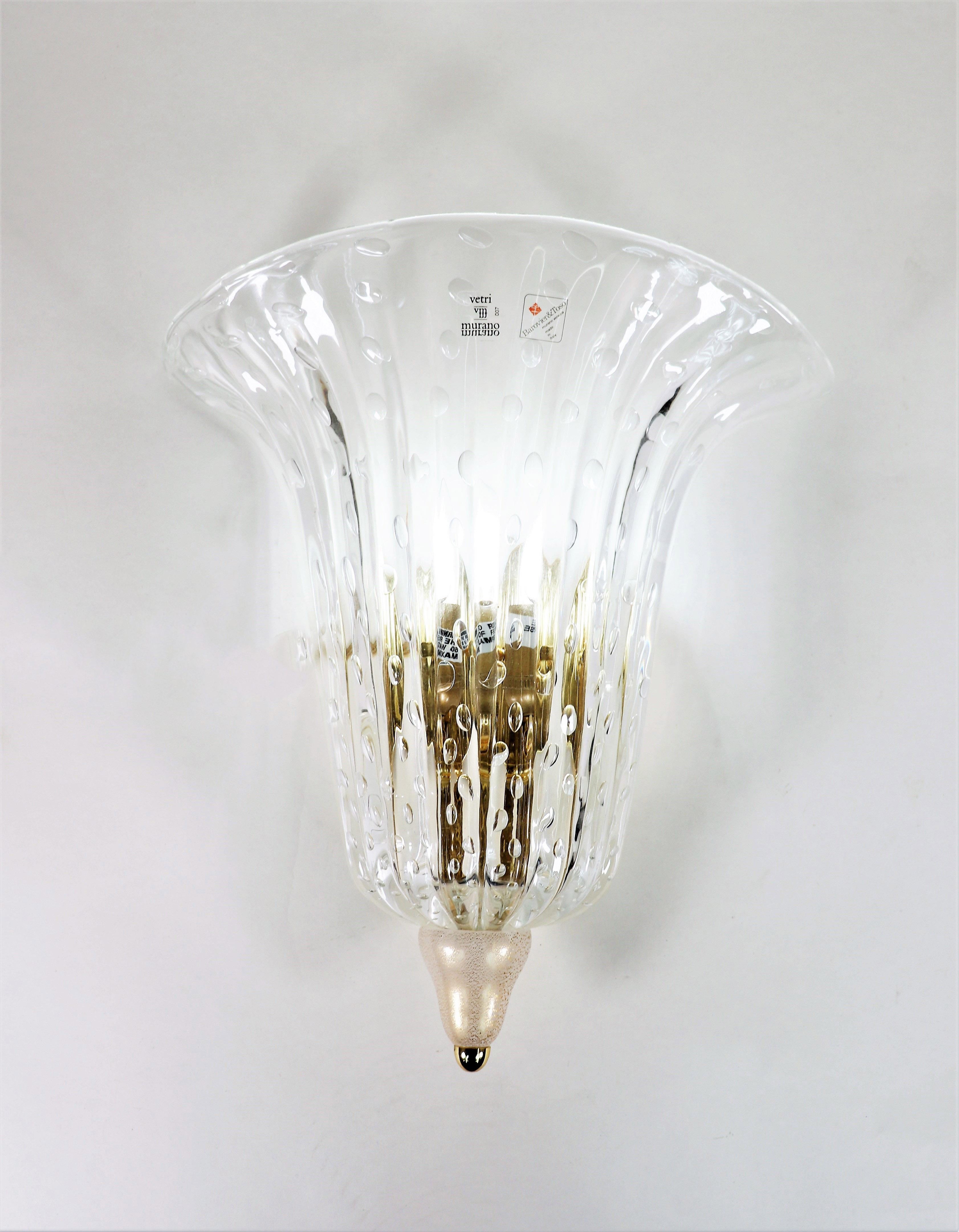 This exquisite sconce is crafted by the legendary Murano glass studio, Barovier and Toso. 

The clear shade is decorated with 