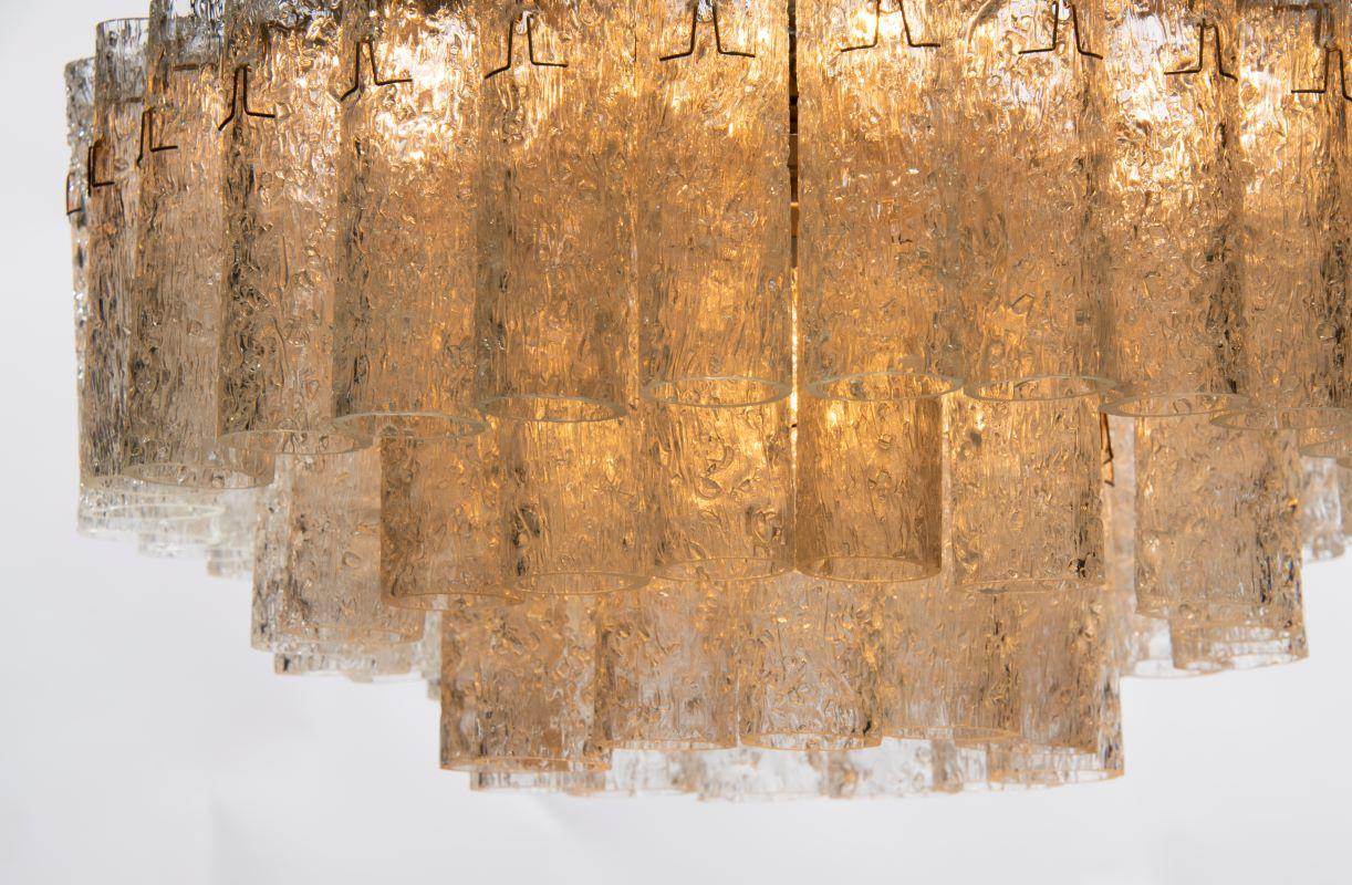 Gorgeous in any setting …three tiers of stunning textured glass cylinders suspended from a polished brass frame​.

Thomas Cooper Studio represents a multilayered, multifaceted collaboration, where materials and techniques join forces in a search for
