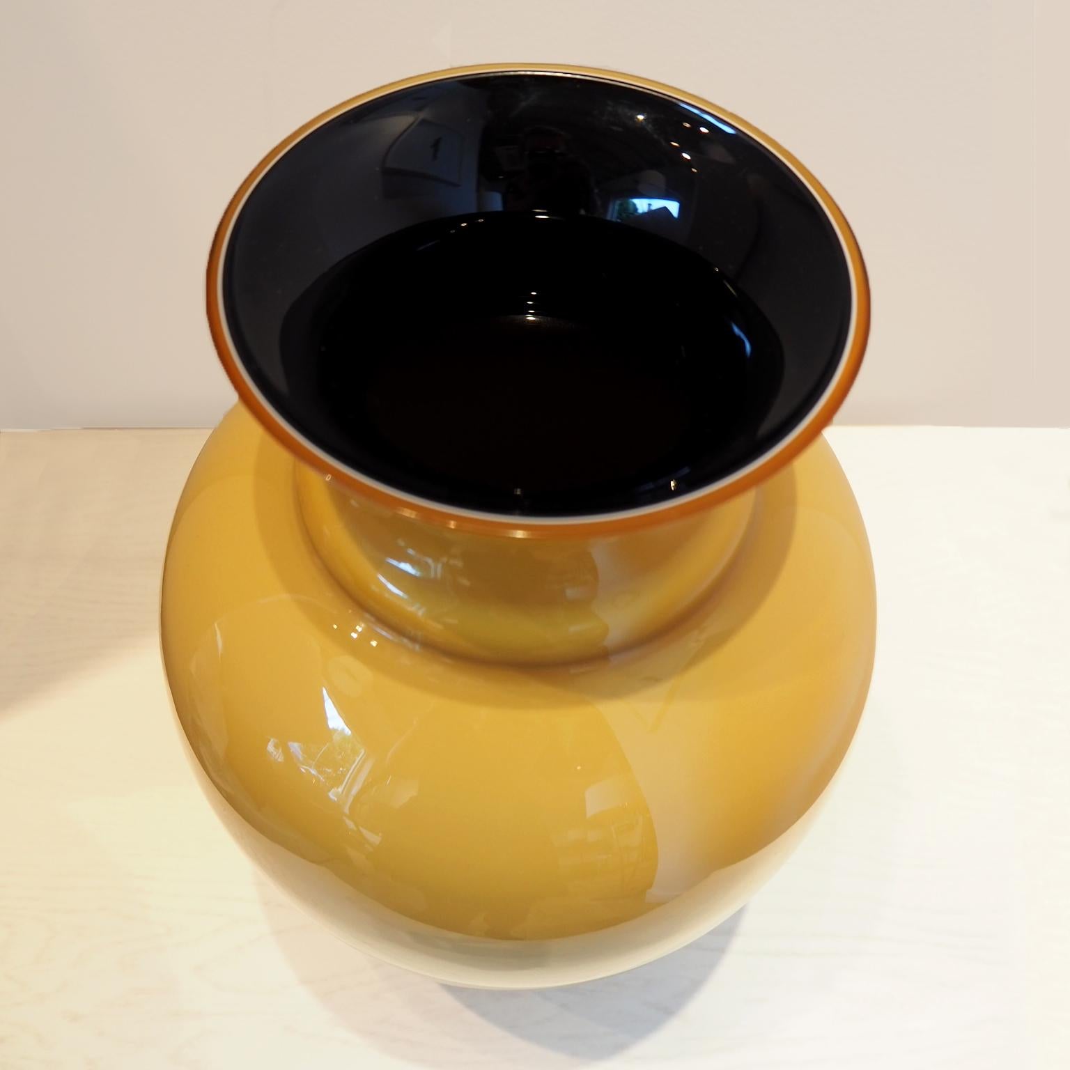 Murano glass vase in mustard colour with black contrasting colour inside.

26Dia x 36H cm

Good vintage condition