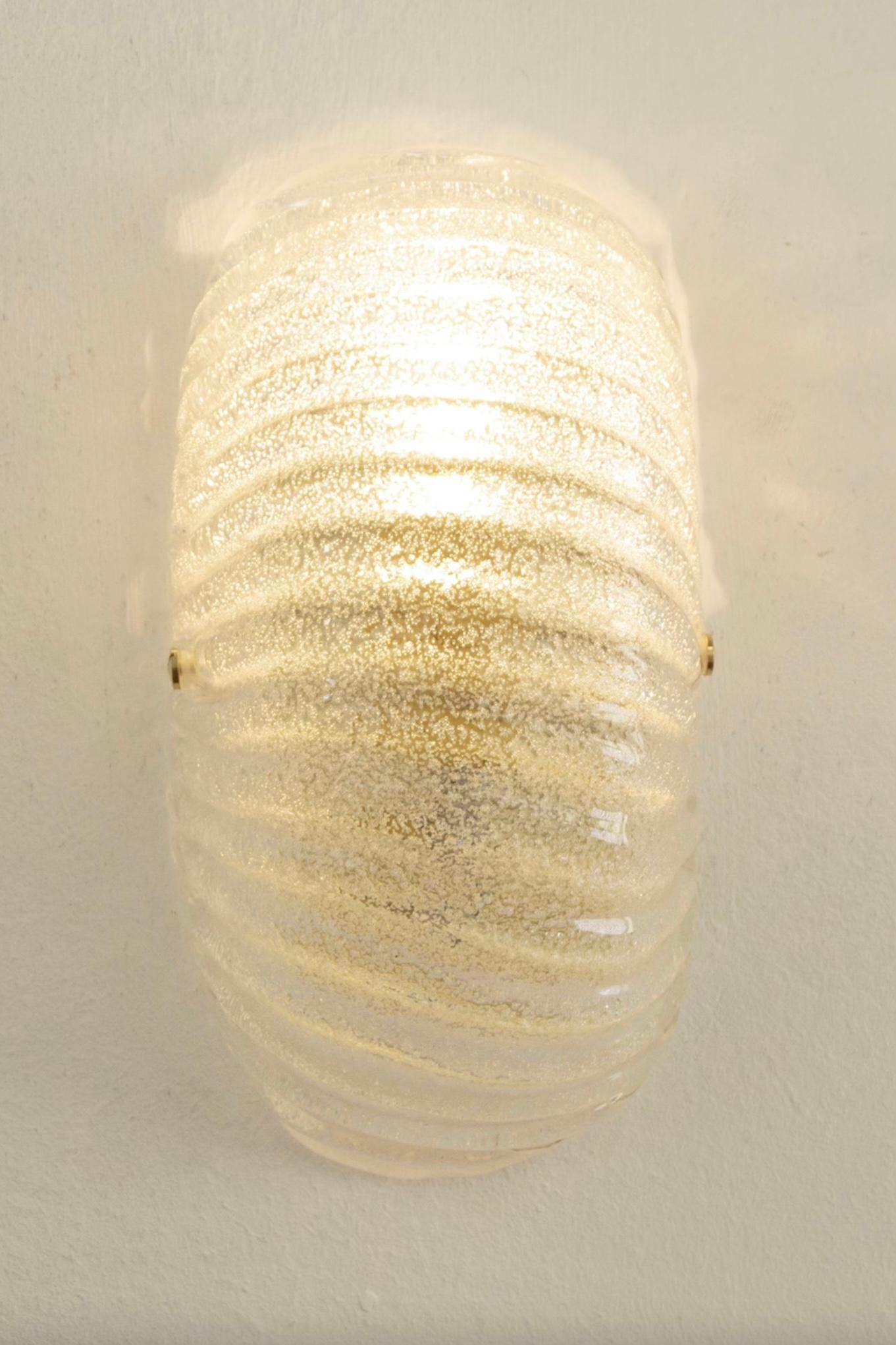 Never-used stunning Murano wall lamp in mouth blown glass with ribbed shell form. Perfect size for your entrance, in the kitchen, in the bathroom or as a reading lamp in the bedroom. Simple and easy to install. 