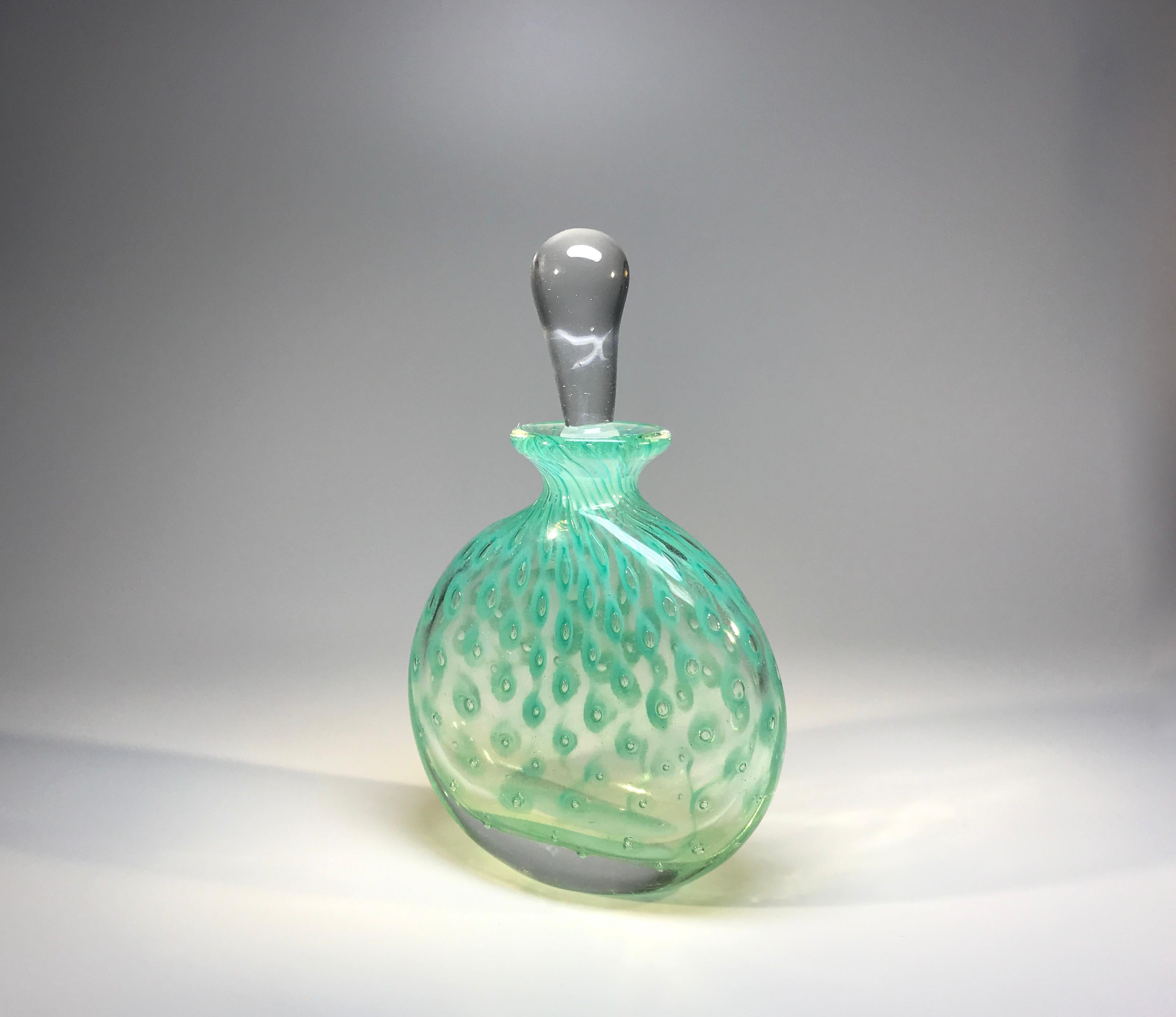 A beautiful vintage Murano, Italy, eau-de-nil controlled bubble, glass perfume bottle attributed to Alfredo Barbini
The piece is very elegant and the eau-de-nil color is superb
circa 1960s
Measures: Height 6 inch, width 5 inch, depth inch
In