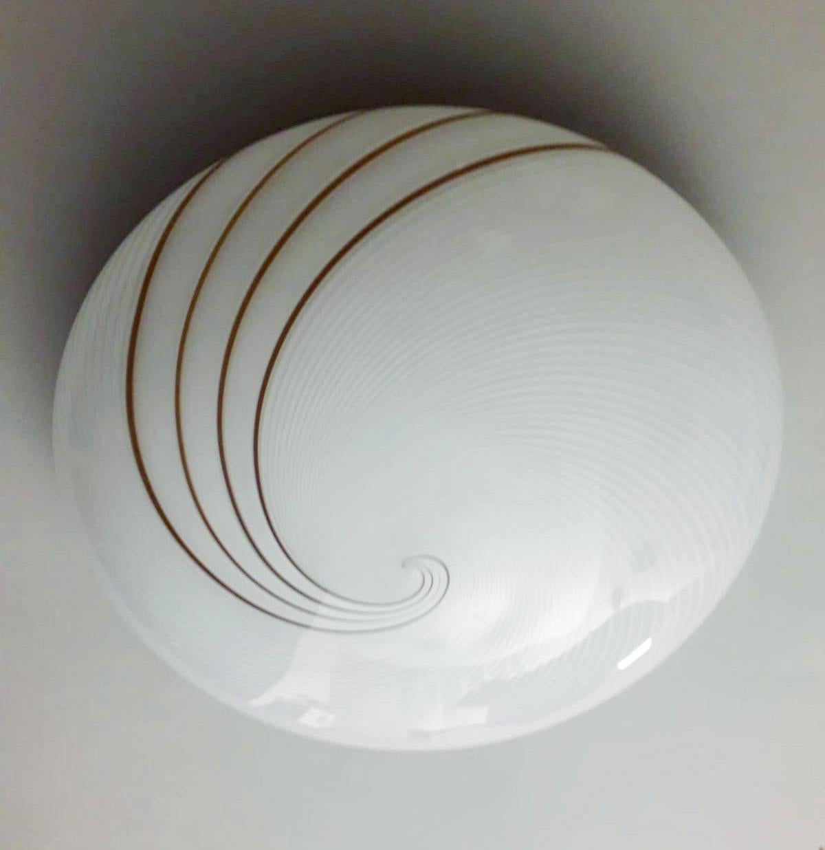 Vintage Italian flush mount or wall light with a single Murano glass shade with ribbed spiral pattern in frosted white and brown colors, mounted white metal frame, in the style of Venini / Made in Italy circa 1960s
Measures: diameter 12 inches,