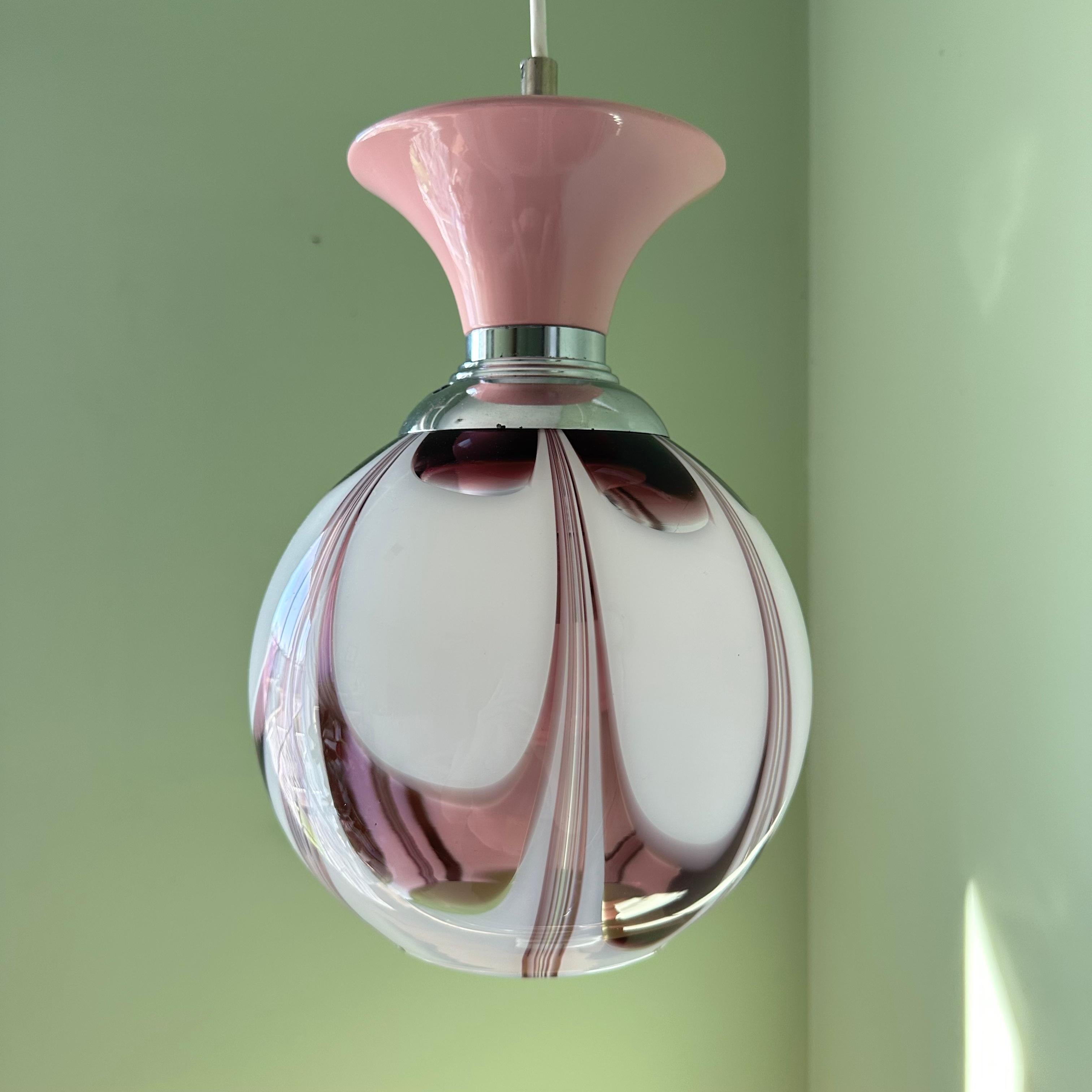 An absolutely beautiful mid century modern vintage Murano blown glass ceiling pendant light in a swirl of amethyst purple and milky white. Capped with additional details in pink and chrome, this feminine fixture was made in Italy. The swirling,