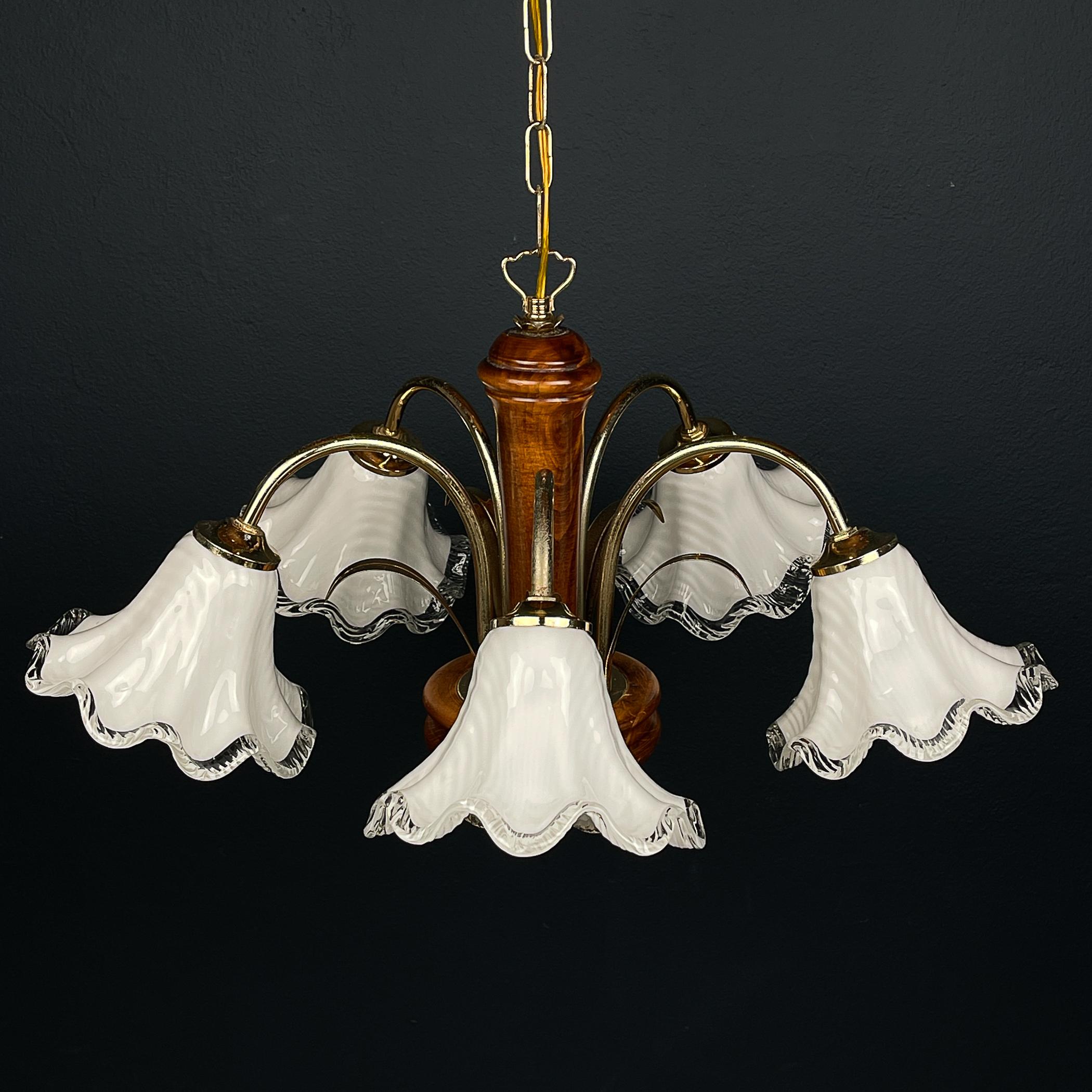 Transport yourself to the charm of 1970s Italy with this vintage Murano glass and wood chandelier, adorned with delicate brass leaf-shaped accents resembling blossoming flowers. Crafted with meticulous attention to detail, this chandelier exudes