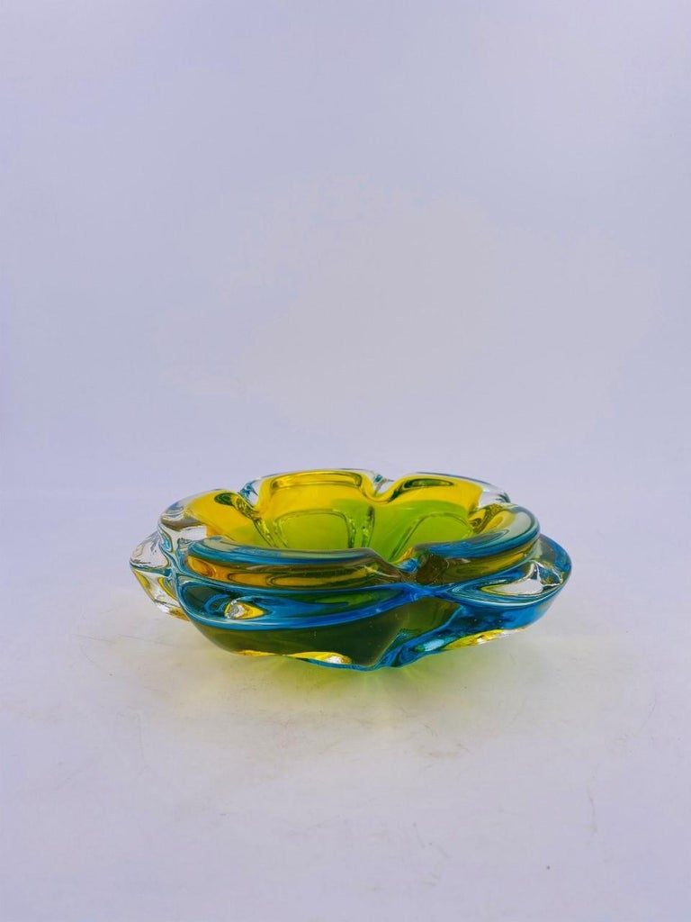 Stunning Murano glass ashtray from the 1950s. Incredible example of midcentury Italian Murano glass ashtrays. Beautiful and sculptural. It features a center area that has a wonderful green hue with red veins that gradually fade into a gold yellow