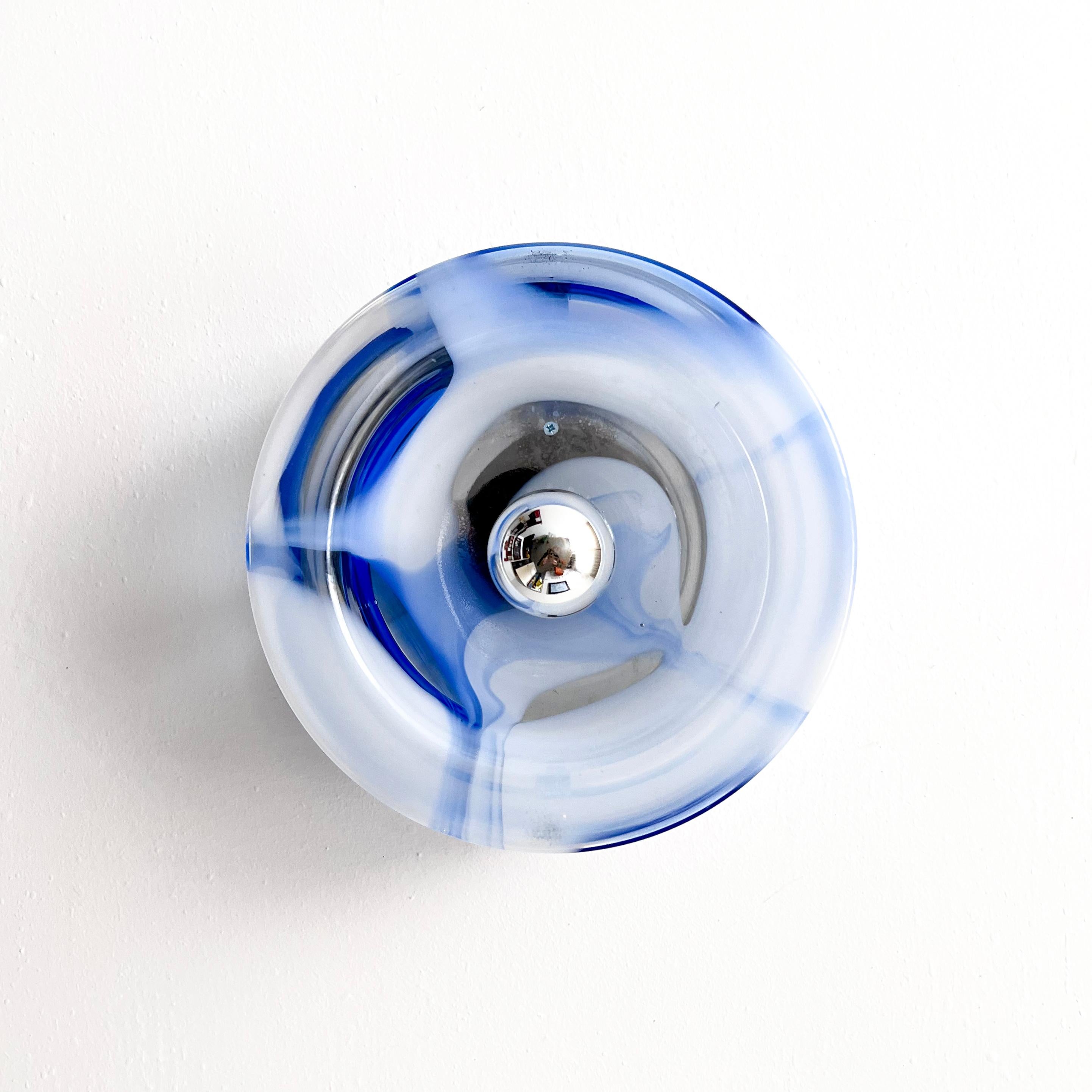 Applique/plafonnier vintage en verre de Murano, fabriqué par Mazzega. Il se compose d'un cylindre transparent, avec des rayures irrégulières et hypnotiques en blanc et en bleu. Le plateau en verre est fixé au cadre métallique par deux vis en métal
