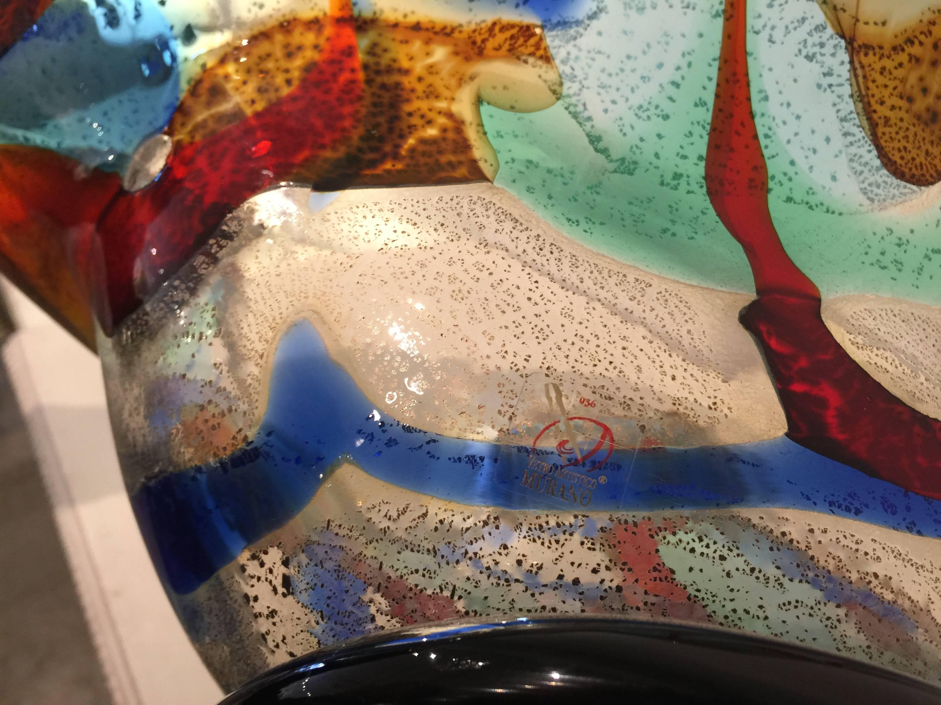 Large centerpiece bowl in rich colors of burgundy, cobalt, amber and sea foam with specks of clear turning to silver.
Signed on the bottom edge by Sergio Costantini. Murano sticker on the bottom and also includes certificate of