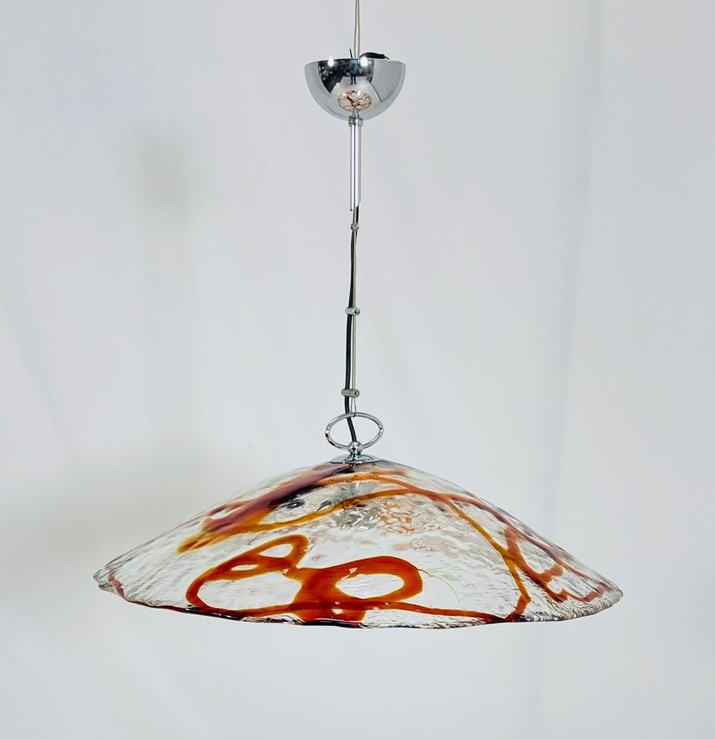 Dieser Vintage-Kronleuchter aus Murano-Glas von Mazzega, der in den swingenden 60er Jahren in Italien hergestellt wurde, verleiht Ihrem Raum die Eleganz vergangener Zeiten. Die atemberaubende Kombination aus orangefarbenem und klarem Murano-Glas