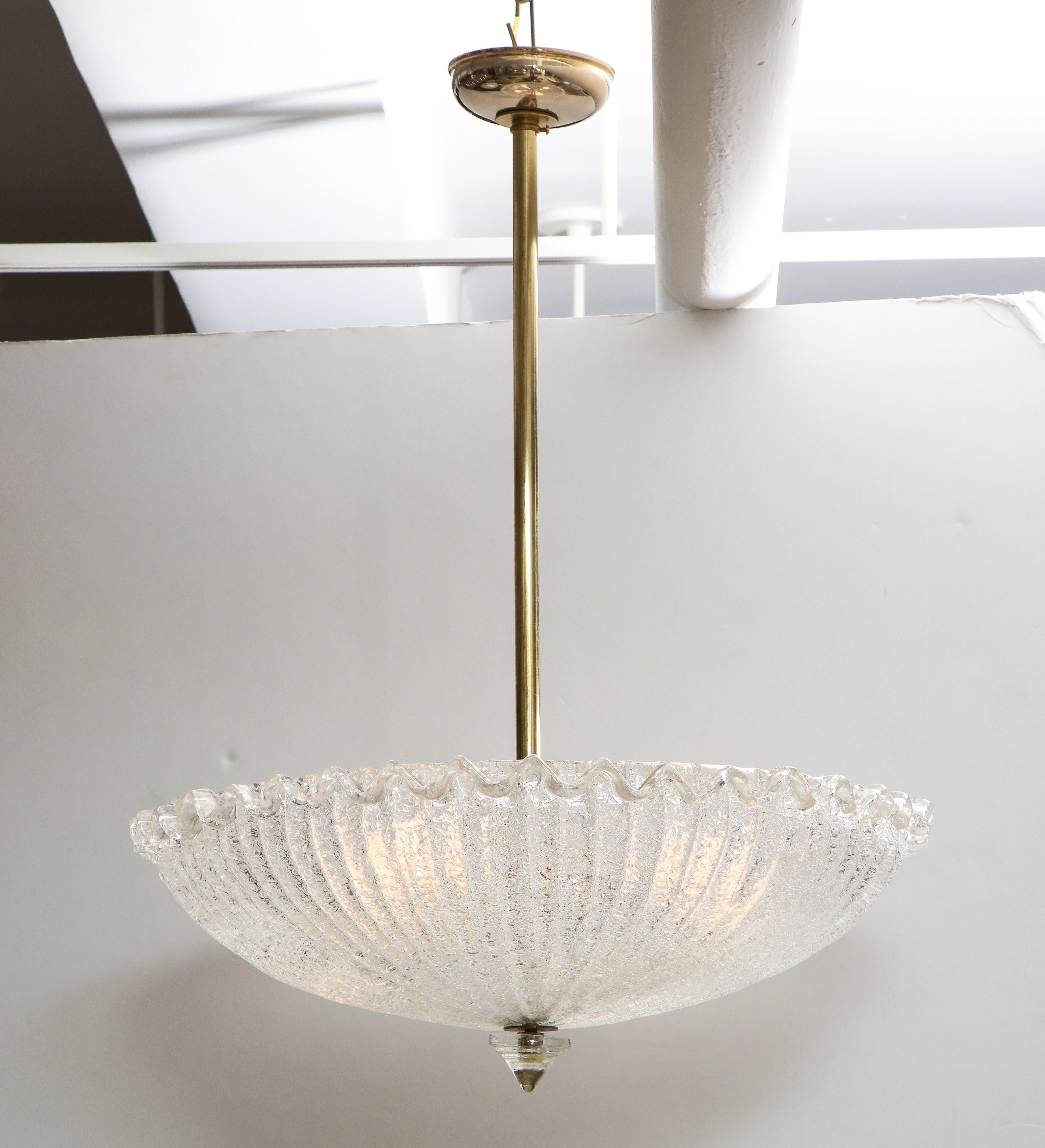 A vintage Murano icy ribbed glass chandelier with scalloped edged surround, supported by contemporary brass column and canopy, with original glass finial. (Re-wired for USA standards). Holds four regular light bulbs. 
Murano, Italy circa 1960