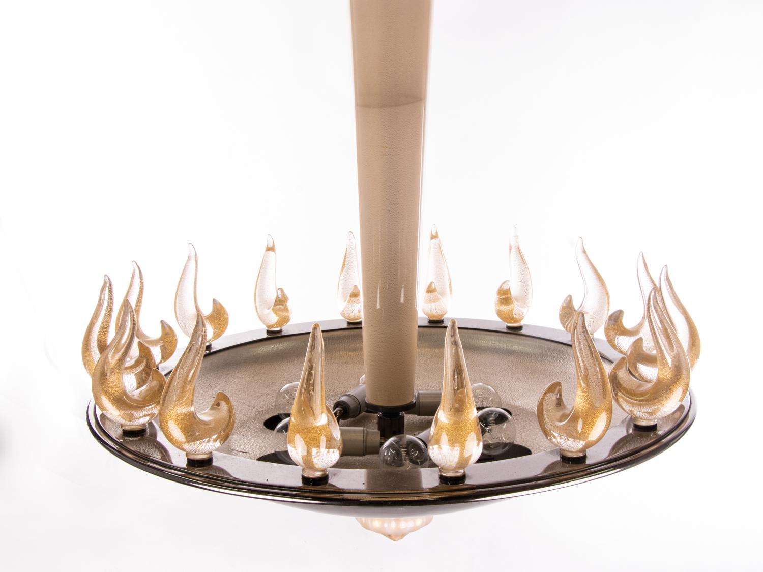 Eleganter und seltener Kronleuchter aus mundgeblasenem venezianischem Murano-Glas mit goldenen Einschlüssen, die elegant um eine schöne dunkle Metallschale wachsen und am Glasstab und Baldachin hängen. 

Jede Flamme wird in das Metallgehäuse