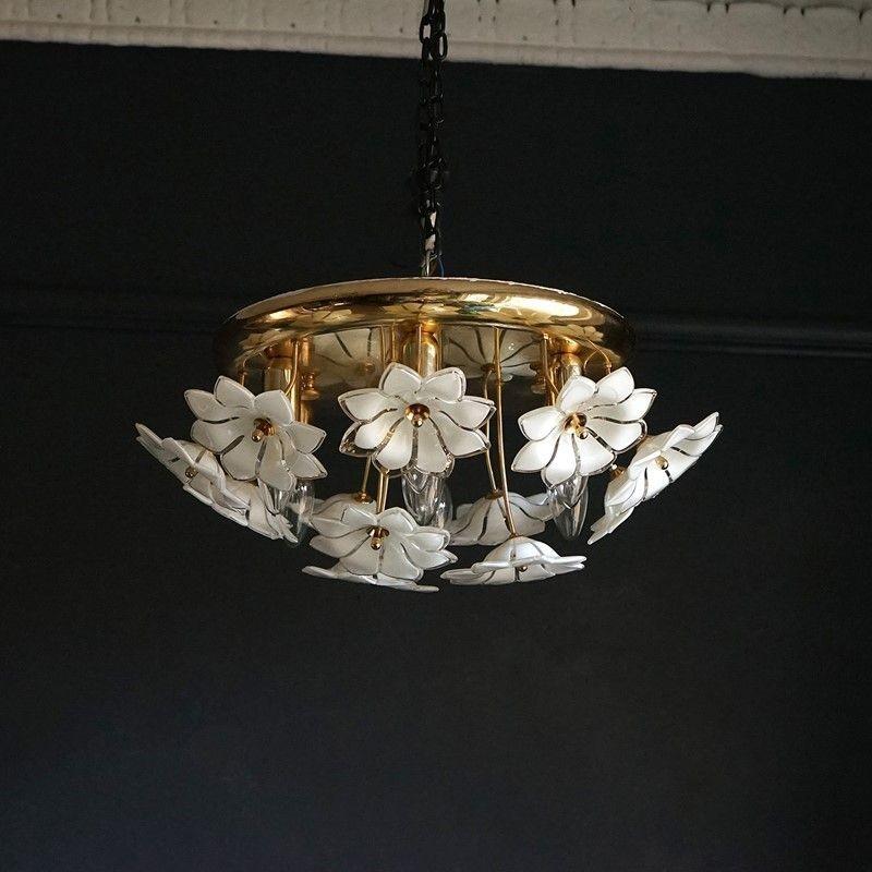 Vintage ceiling light

Handblown opaline and clear glass flowers sit on gold-plated stems in front of seven light fittings on a gold-plated flush-mounted ceiling plate.

It is in excellent vintage condition there is some very minor wear and tear