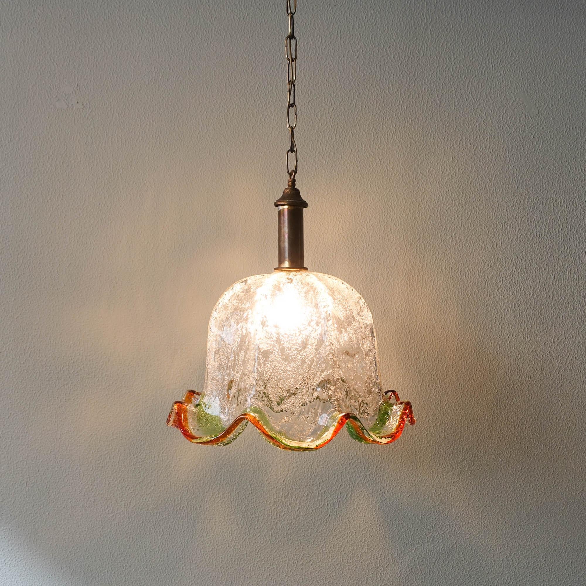Dieser Kronleuchter aus Muranoglas wurde in den 1970er Jahren von Carlo Nason für Mazzega in Italien entworfen. Diese Lampe hat einen Lampenschirm aus Muranoglas mit Blumenmuster. Hergestellt aus strukturiertem Klarglas mit bernsteinfarbenem und