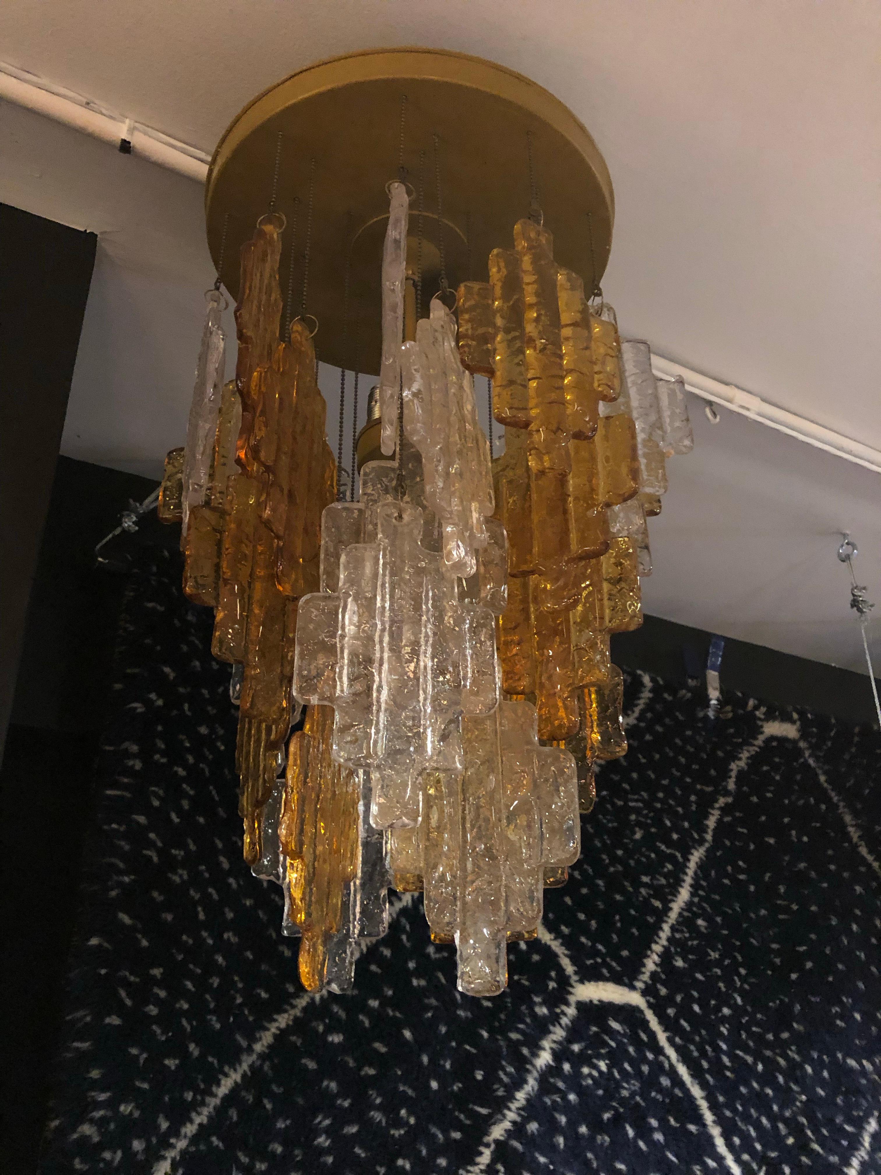 A beautiful Italian Murano chandelier featuring geometric shaped hand blown glass details. One single center rod accommodates 6 bulbs. Brass frame. 

Dimensions: 22” H x 14” D

Condition: This item has been newly rewired and restored.