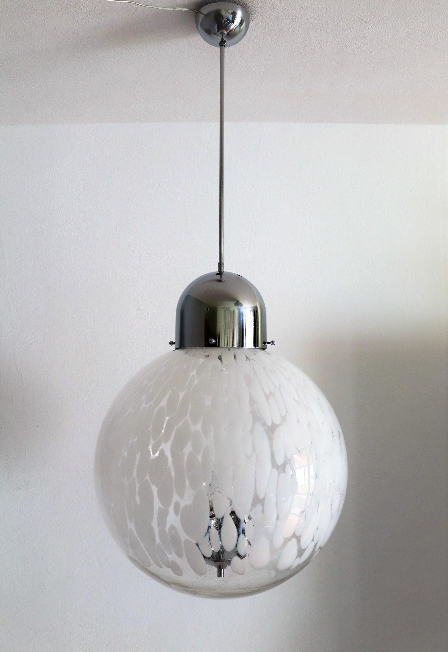 Gorgeous pendant light with big Murano glass globe in mottled glass and chromed lamp base.
The glass has a very big diameter and is in very good condition. The chrome have been polished and is shiny with small signs of age and patina.
Equipped