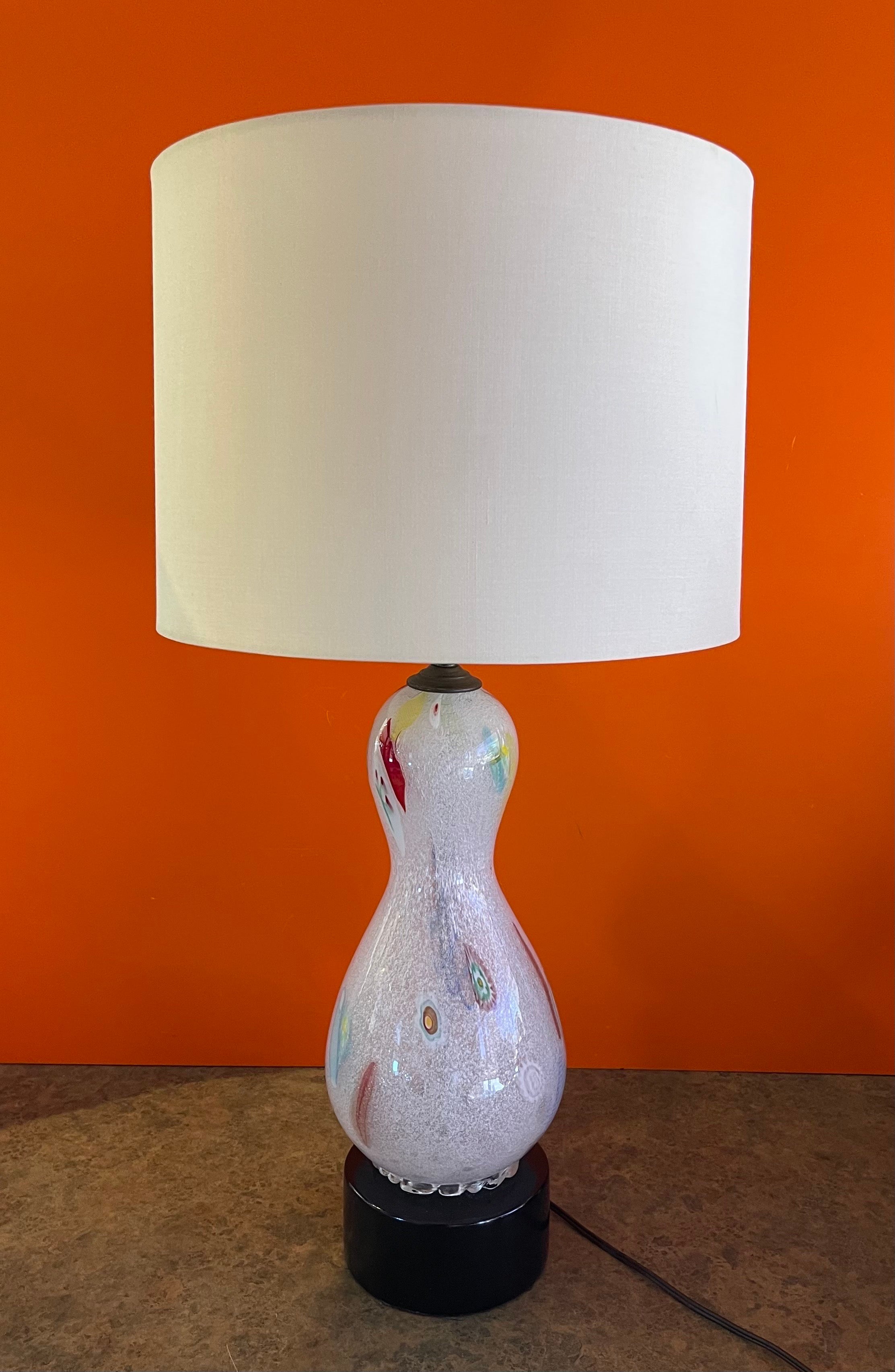 Stunning vintage Murano Glass millefiori table lamp on an ebonite wood base, circa 1950s.  Millefiori is the art glass technique in which colored glass rods are fused and cut to create flower patterns; an ancient technique revived in Venice in the
