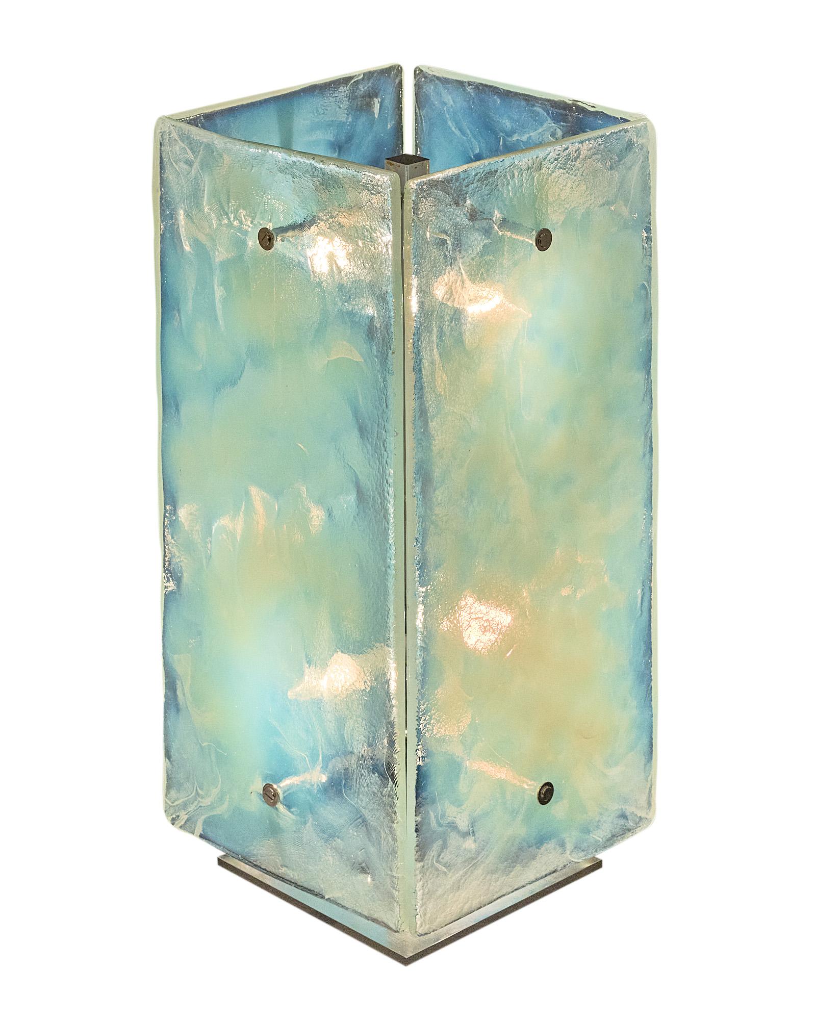 Vintage pair of Murano glass table lamps featuring a striking iridescent finish to the glass panels. Each lamp has four iridescent hand-blown glass panes affixed to a chrome finished structure. This pair creates an ethereal effect as the light